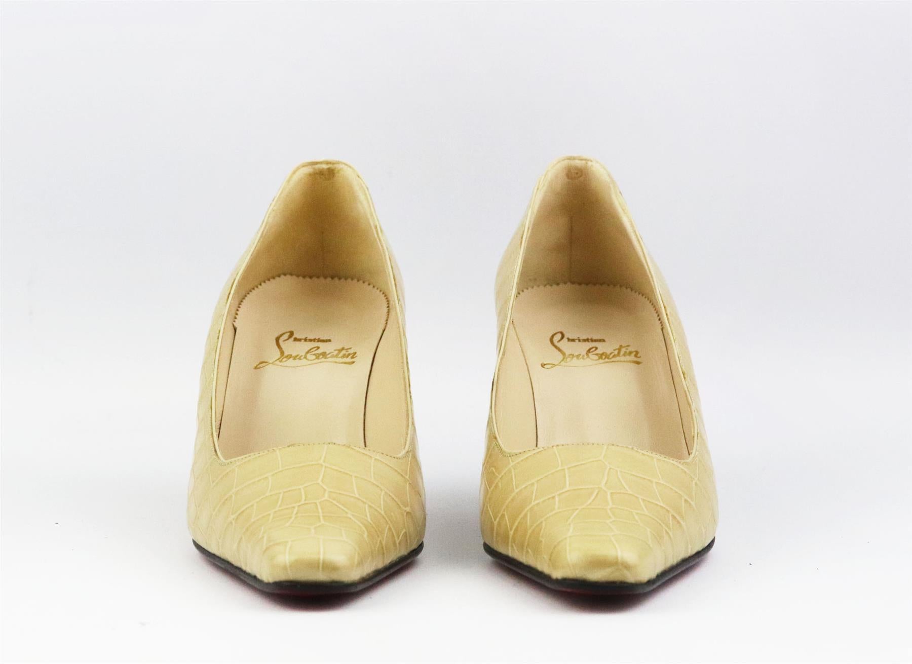 These vintage pumps by Christian Louboutin have been made in Italy and have pointy square toes and is made from beige crocodile skin and finished with a red sole. Heel measures approximately 57 mm/ 2.25 inches. Beige crocodile. Slips on. Does not