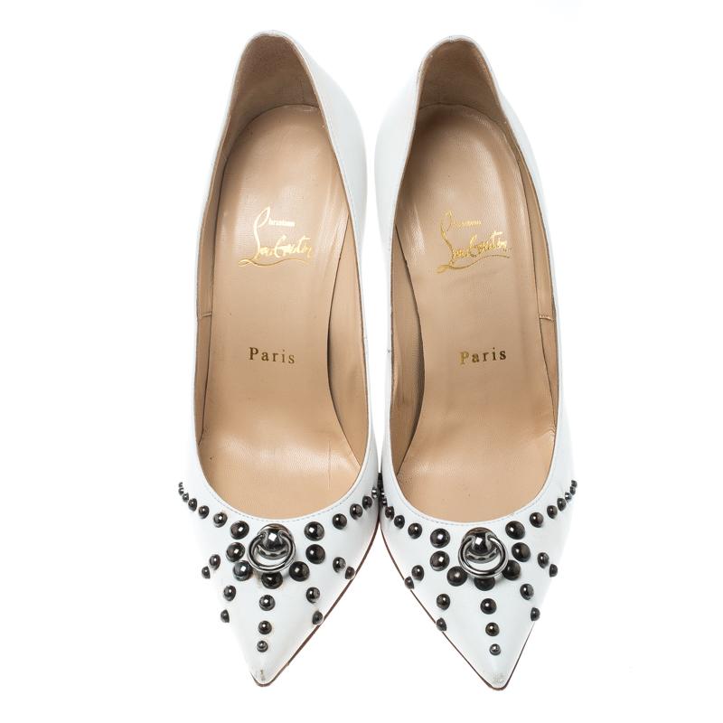 Glamour is personified by these Christian Louboutin pumps. Crafted in leather, these pumps in white are accented with black-tone hardware. They feature pointed toes, metallic studs on toe caps and vamps, and a mock door-knock detailing on the vamps.