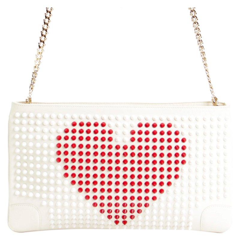 This bag from Christian Louboutin is for the true lovebird! Crafted from 100 percent genuine leather, the clutch is pure white in colour and is embossed with white and red coloured studs. It has a striking gold coloured chain as the shoulder strap