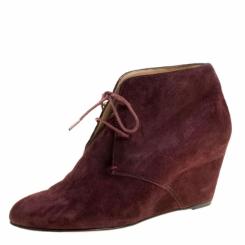Ces bottes Compacta de Christian Louboutin méritent toute votre attention ! Confectionnées en daim dans une jolie teinte lie-de-vin, elles présentent des bouts ronds et des lacets sur l'empeigne. Ils sont équipés de semelles intérieures confortables
