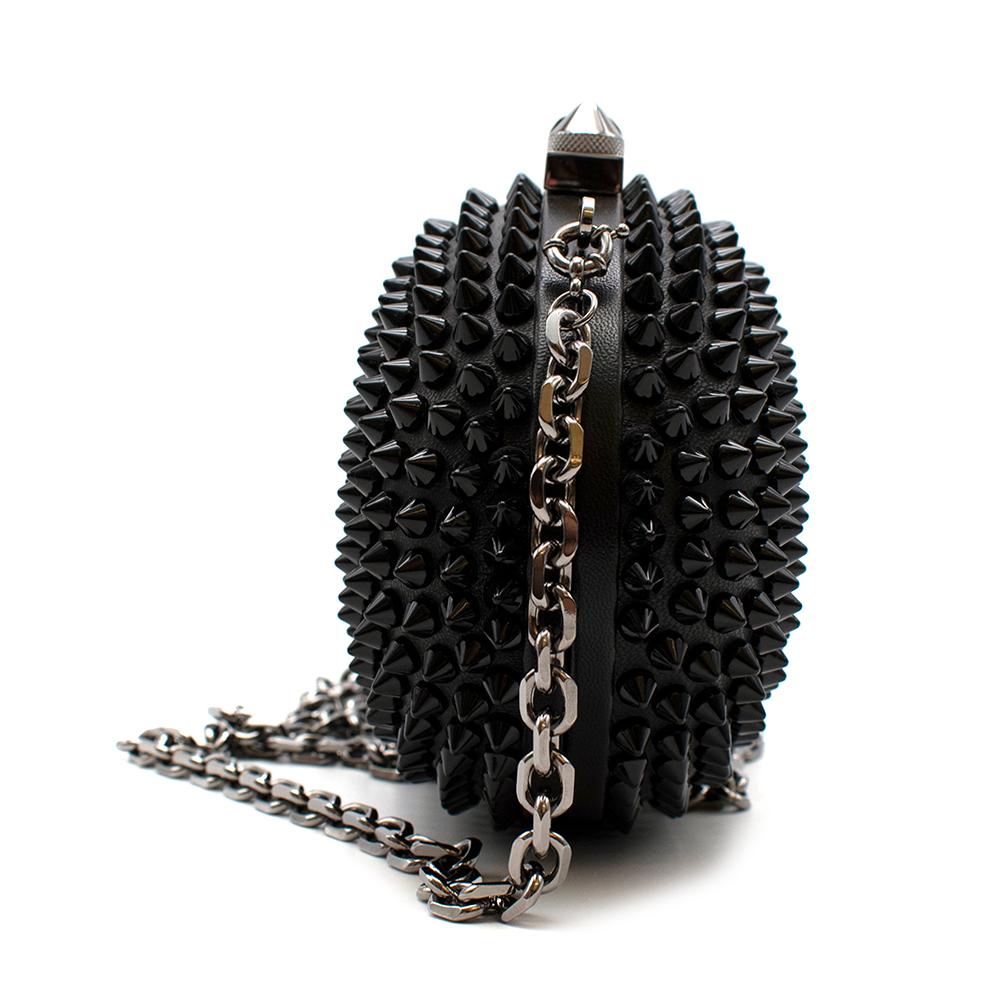 Christian Louboutin Womens 
Black Mina Spiked Oval Clutch 

- Detachable Shoulder Strap Chain
- Brands Signature Spikes
- Black Hardware 
- Push Lock Fastening 
- Fully Lined In Red Leather 

Material:
- 100% Calf Leather 
- Lamb Leather Lining