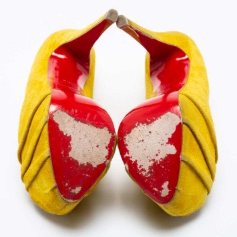 Made distinctive by the ruched detailing on the vamp, these Christian Louboutins Drapesse pumps are a House signature. These shoes are presented in yellow suede. In addition to covered heels, they have concealed platforms for extra support. They