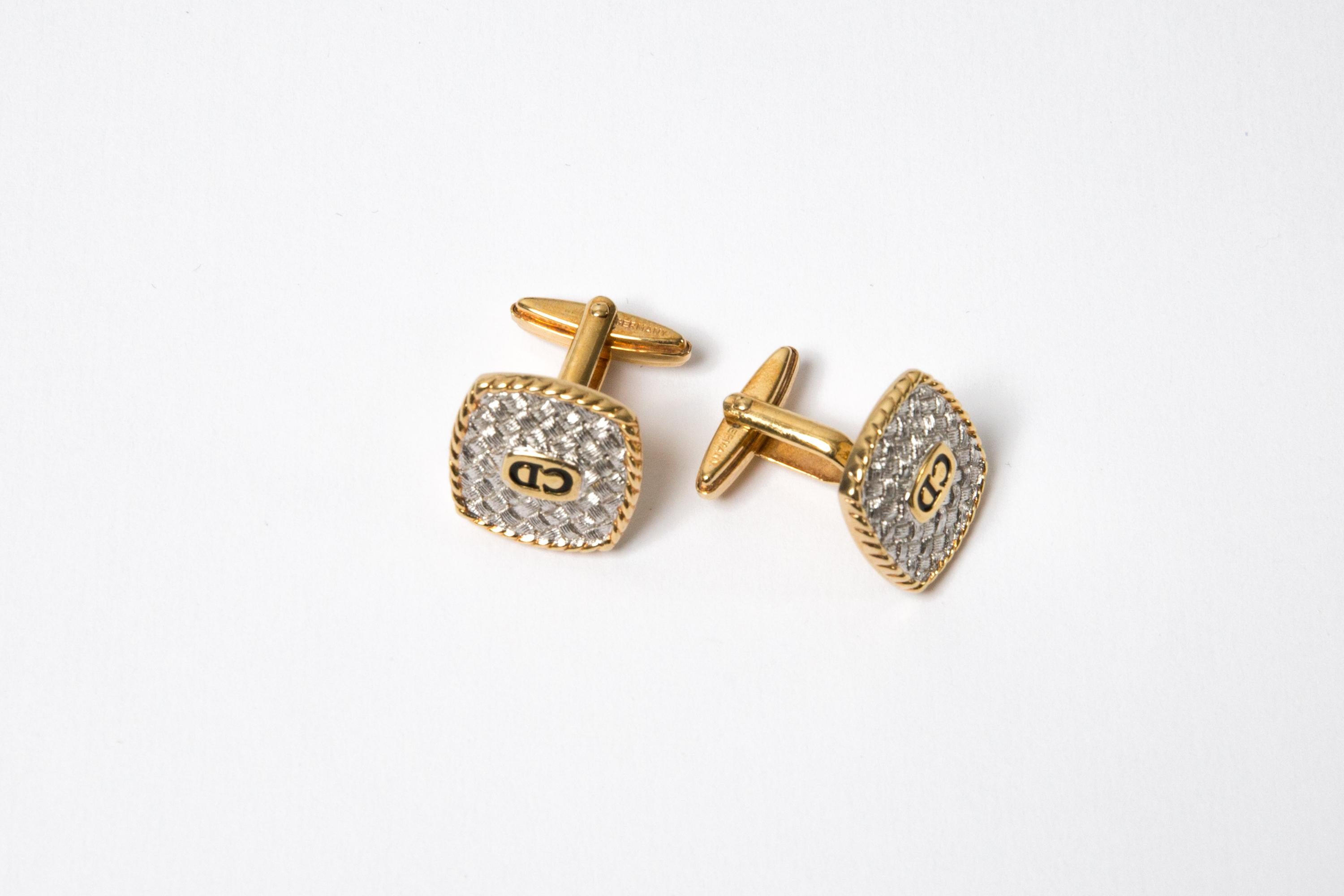 L'ensemble pince à cravate et boutons de manchette Christian Dior en métal argenté présente une forme carrée, un fond texturé, un CD noir central piqué d'un contour en métal doré. Elles sont livrées par paire + un accessoire de cravate.
Circa 1990