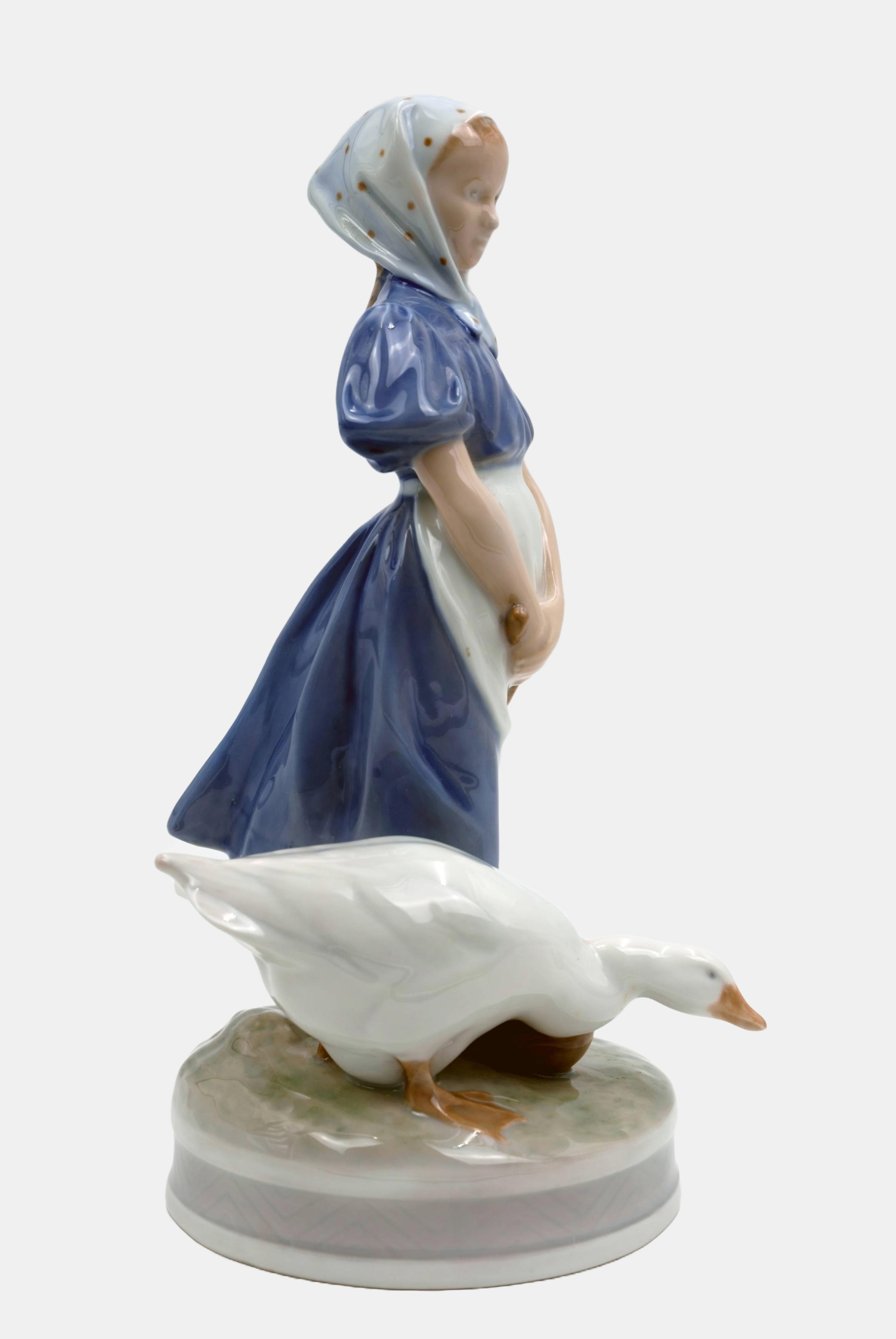 Christian Thomsen (1860 Kolding - 1921 Kopenhagen), Bauernmädchen mit Gans, Entwurf um 1910, Ausführung 1966. Modellnummer 527. Erste Wahl. Porzellan mit Unterglasurmalerei. 23,5 cm (Höhe) x 12 cm (Länge) x 14 cm (Tiefe). Mit der Ligatur von