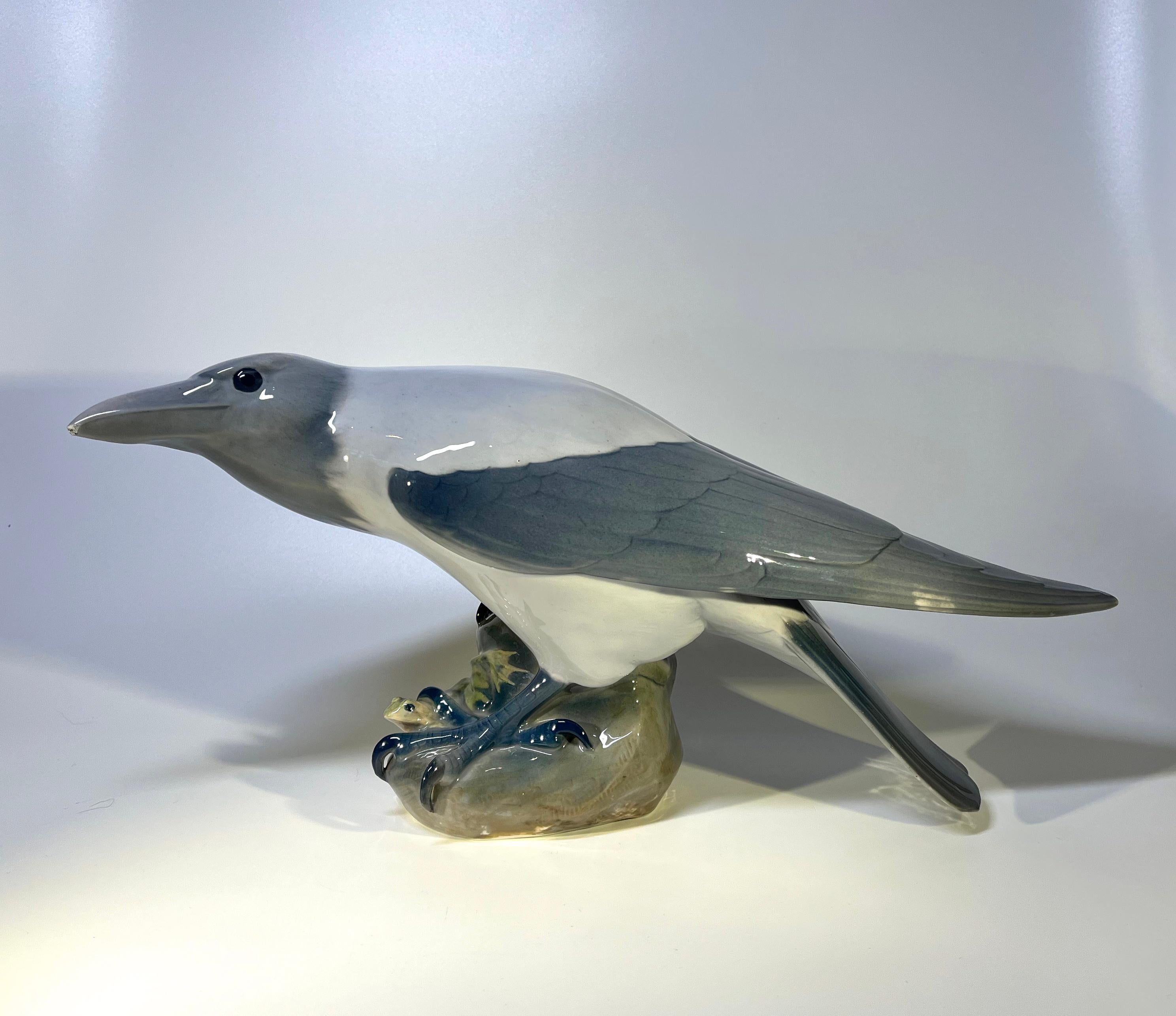 Imposing Art Nouveau Crow figurine created in 1901 by Christian Thomsen for Royal Copenhagen 
This formidable antique porcelain figurine features a a frog entrapped on a rock by the claws of it's predator, the hooded crow
A collectors