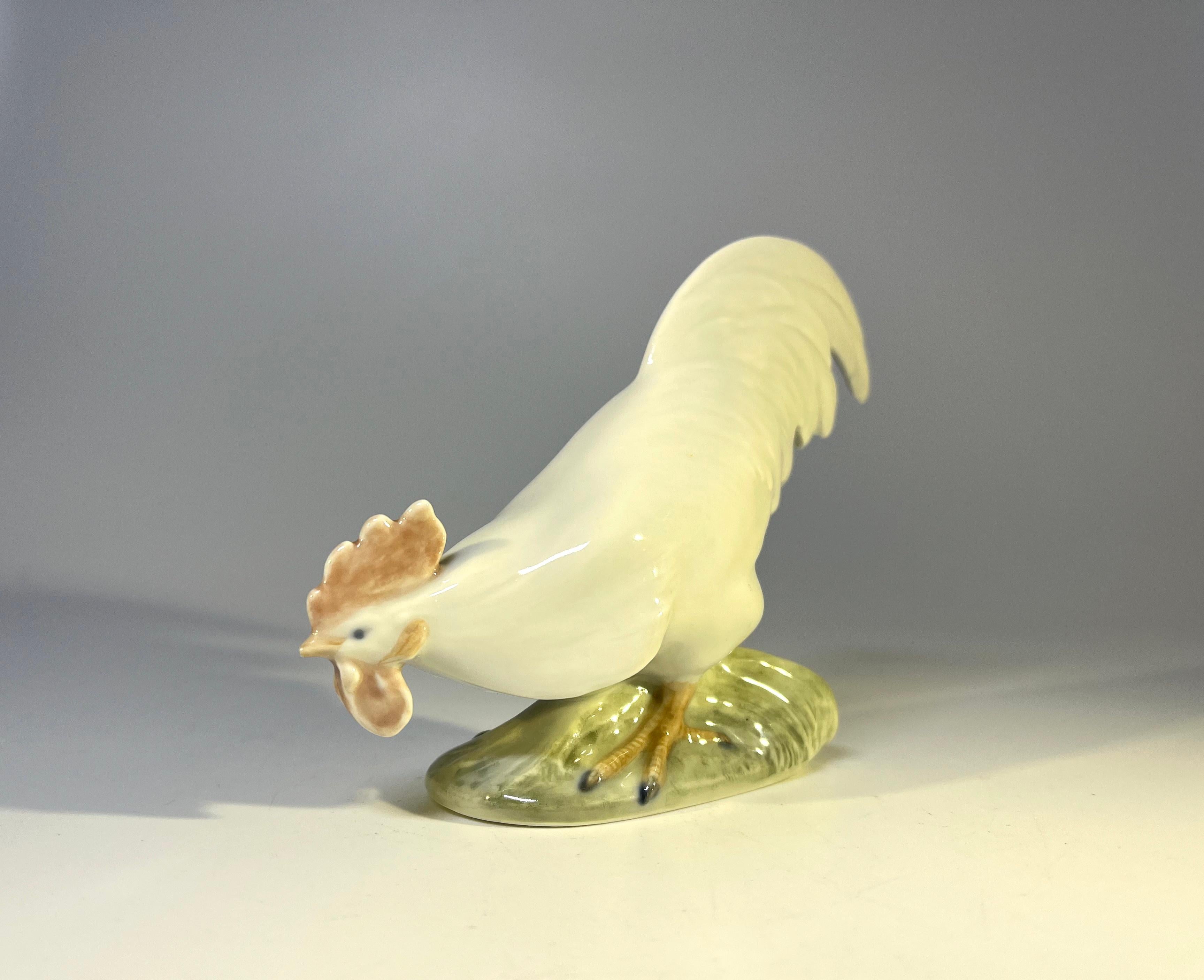 Figurine en porcelaine de Christian Thomsen pour Royal Copenhagen, représentant un coq en quête de nourriture. 
Créée en 1923, une pièce de collection classique.
Signé et numéroté 1127
Circa 1923
Hauteur 4 pouces, Largeur 5 pouces, Profondeur 1.5