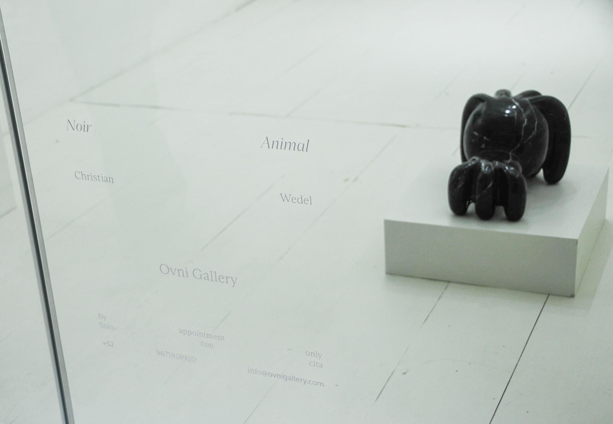 Noir Animal è una presenza imponente, scolpita nel marmo nero e modellata con un'intensità tranquilla che suggerisce forza e mistero. La sua forma evoca una figura di guardiano, vigile ma invitante, come se fosse posizionata sulla soglia di un mondo