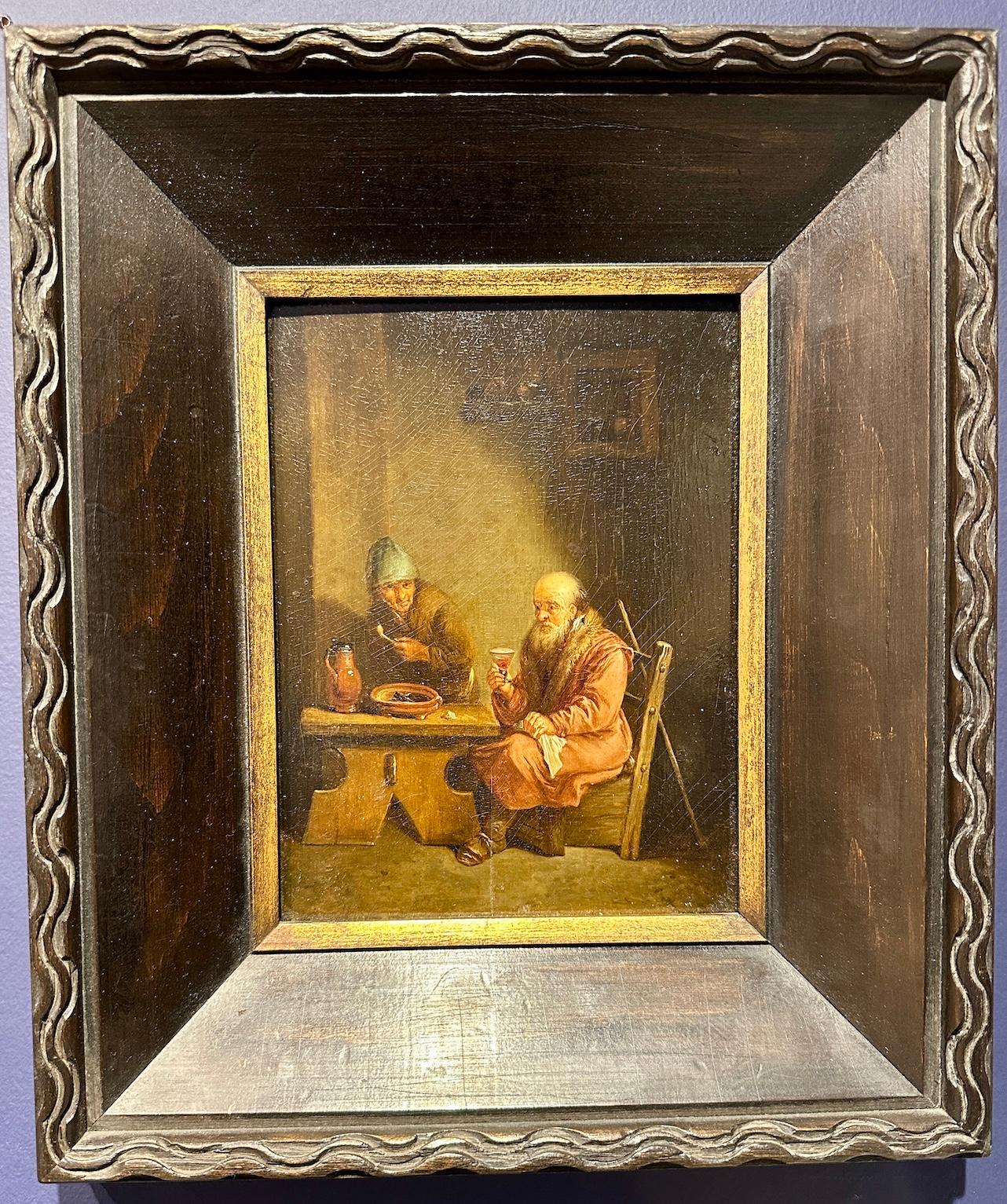 Interior de posada de estilo antiguo con tres hombres bebiendo alrededor de una mesa