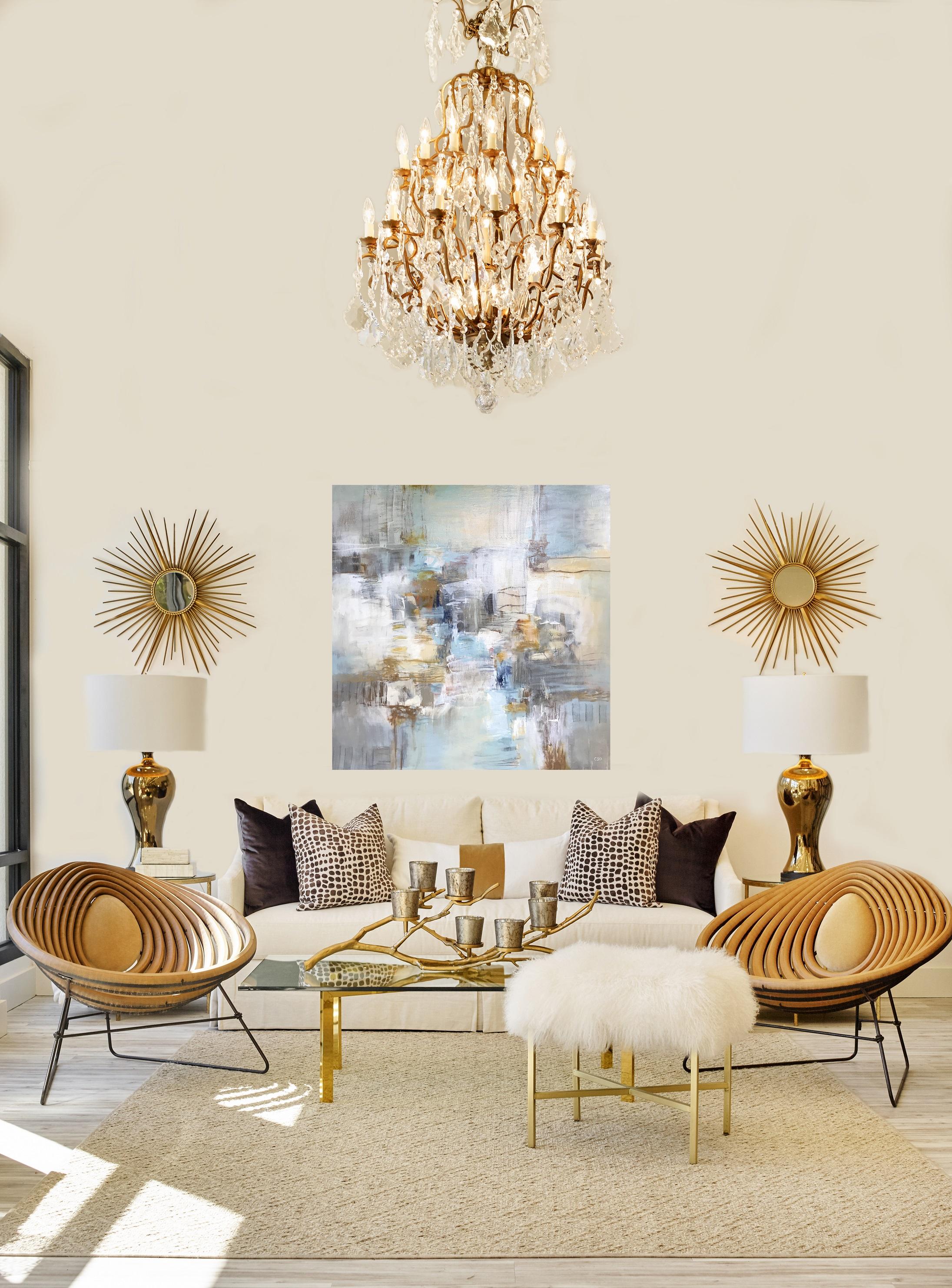 'Coastal Morning' is a large mixed media on canvas abstract painting created by American artist Christina Doelling in 2018. Featuring a soft palette mostly made of pale blue, white, beige and tan colors highlighted by golden accents, this square