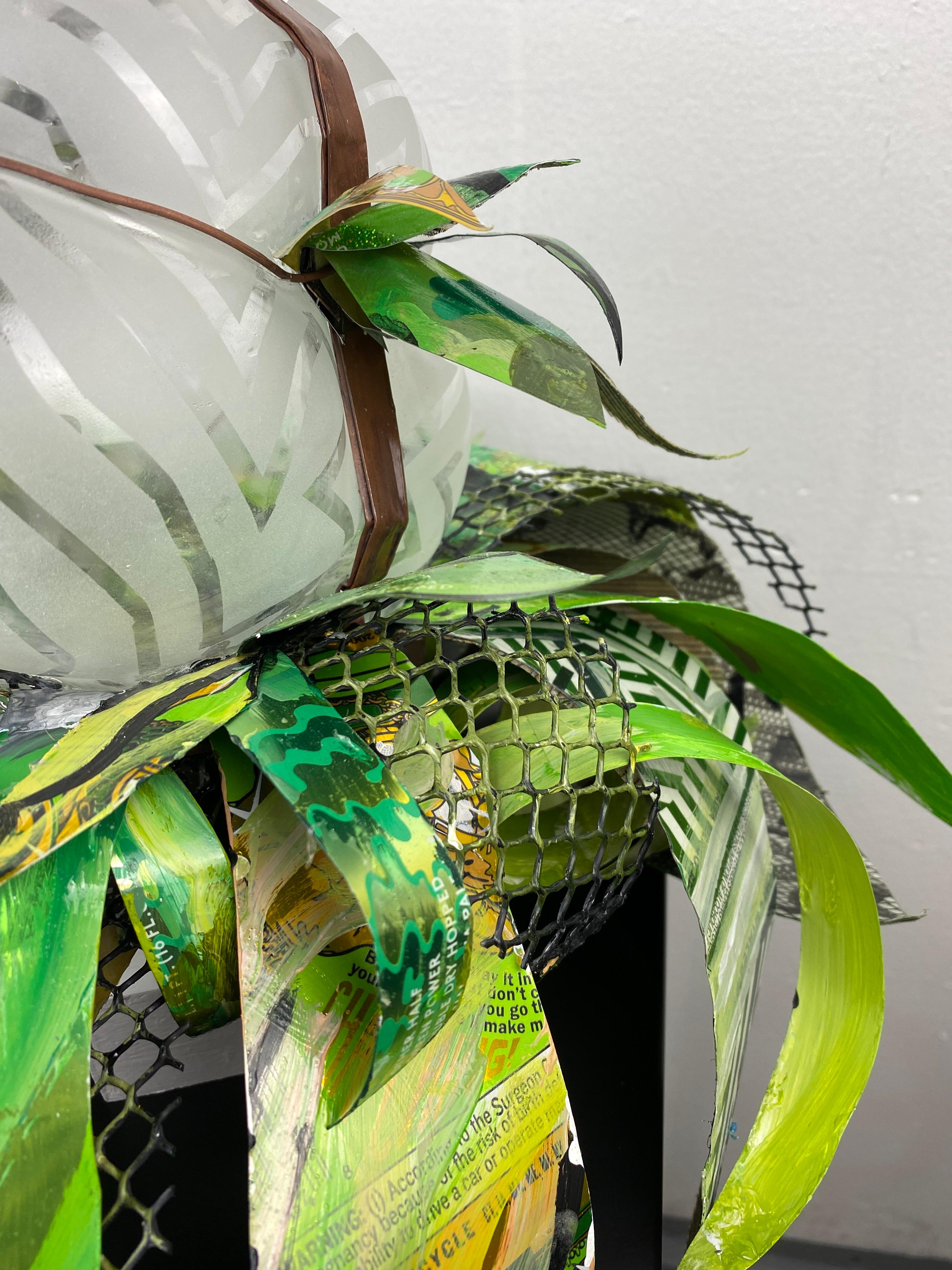 Clairaperennial 7, part of a series of contemporary glass mixed media abstract botanical plant sculptures made from blown glass, repurposed copper and aluminum sourced from craft beer cans, wire and acrylic paint. The work has a magnetized base to