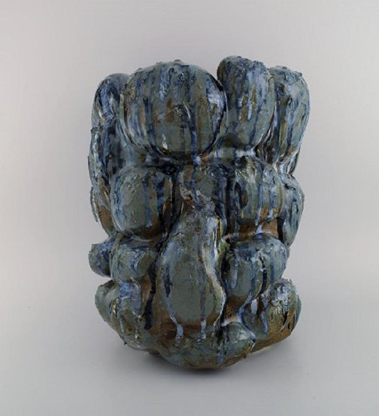 Christina Muff, dänische zeitgenössische Keramikerin (geb. 1971). 
Große skulpturale Vase aus Steingut, von Hand modelliert, mit Ausbuchtungen. 
Dieses Gefäß ist in Grau- und Blautönen glasiert, mit braunen Bereichen in der Tiefe. 
Teil der Reihe