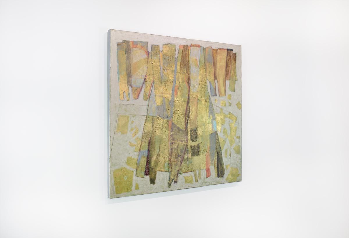This abstract painting features cool grey background and layers of metallic gold throughout. The central abstract form is composed of imperfect shapes placed side by side. The painting has neutral painted sides and is signed by the artist on the