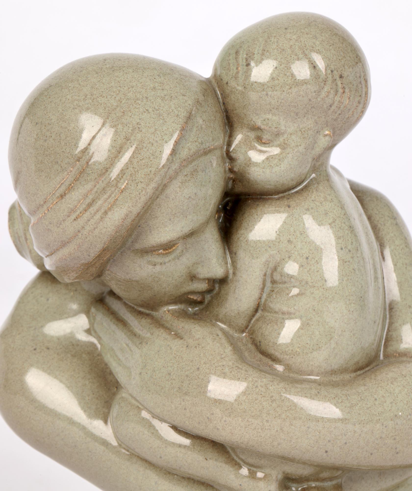 Eine schöne Art-Déco-Keramikskulptur einer Mutter mit Kind von Christine Gregory (Britin, 1879-1965) aus dem Jahr 1933. Diese sehr zärtliche und gut beobachtete Darstellung zeigt die Mutter, die das Kind in ihren Armen hält und mit ihrem fließenden