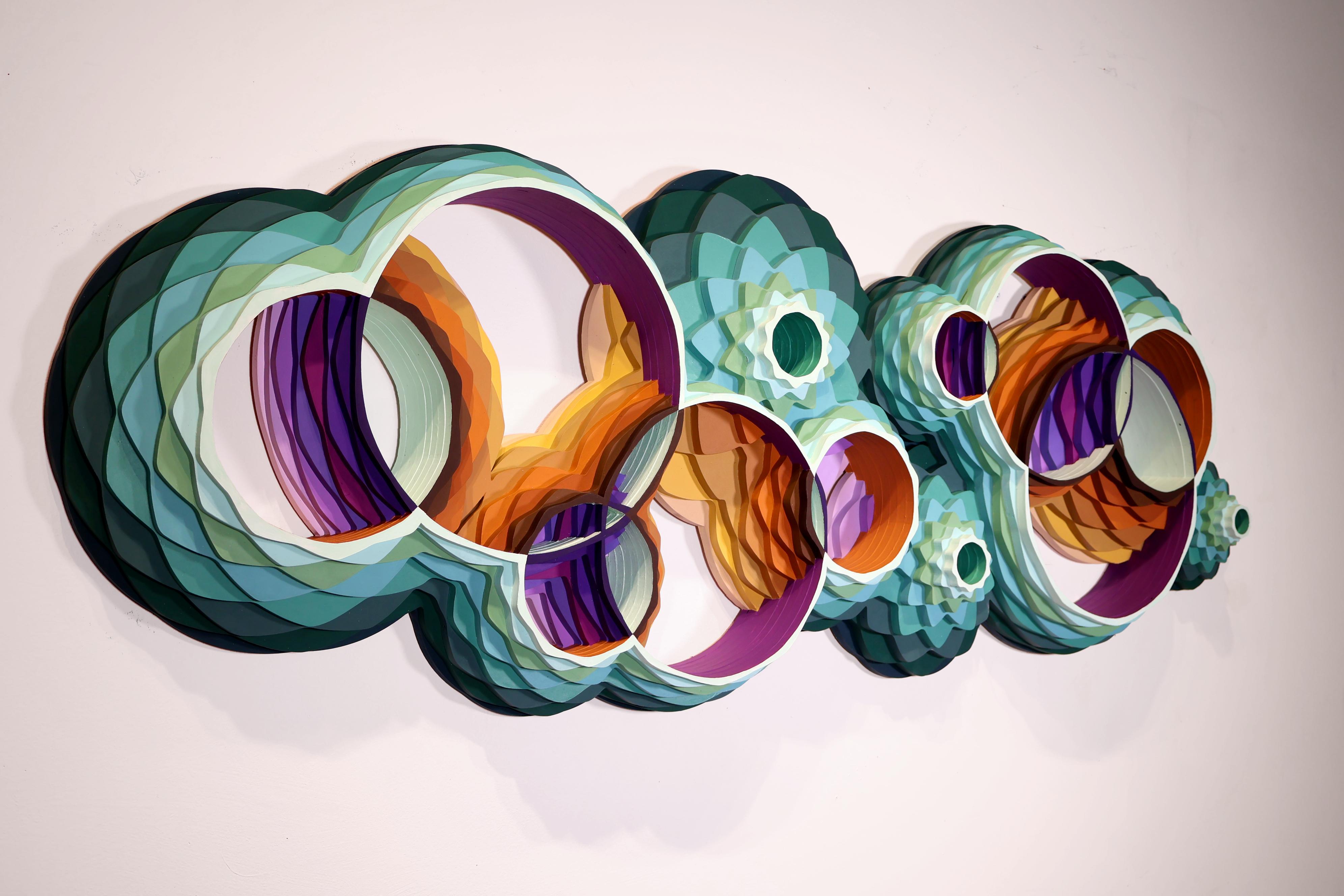 La sculpture murale géométrique Aqua Infinite Diversity présente un design tridimensionnel audacieux avec des formes circulaires imbriquées qui évoquent le mouvement des vagues de l'océan et la vie marine. Créée par Christine Romanell, cette