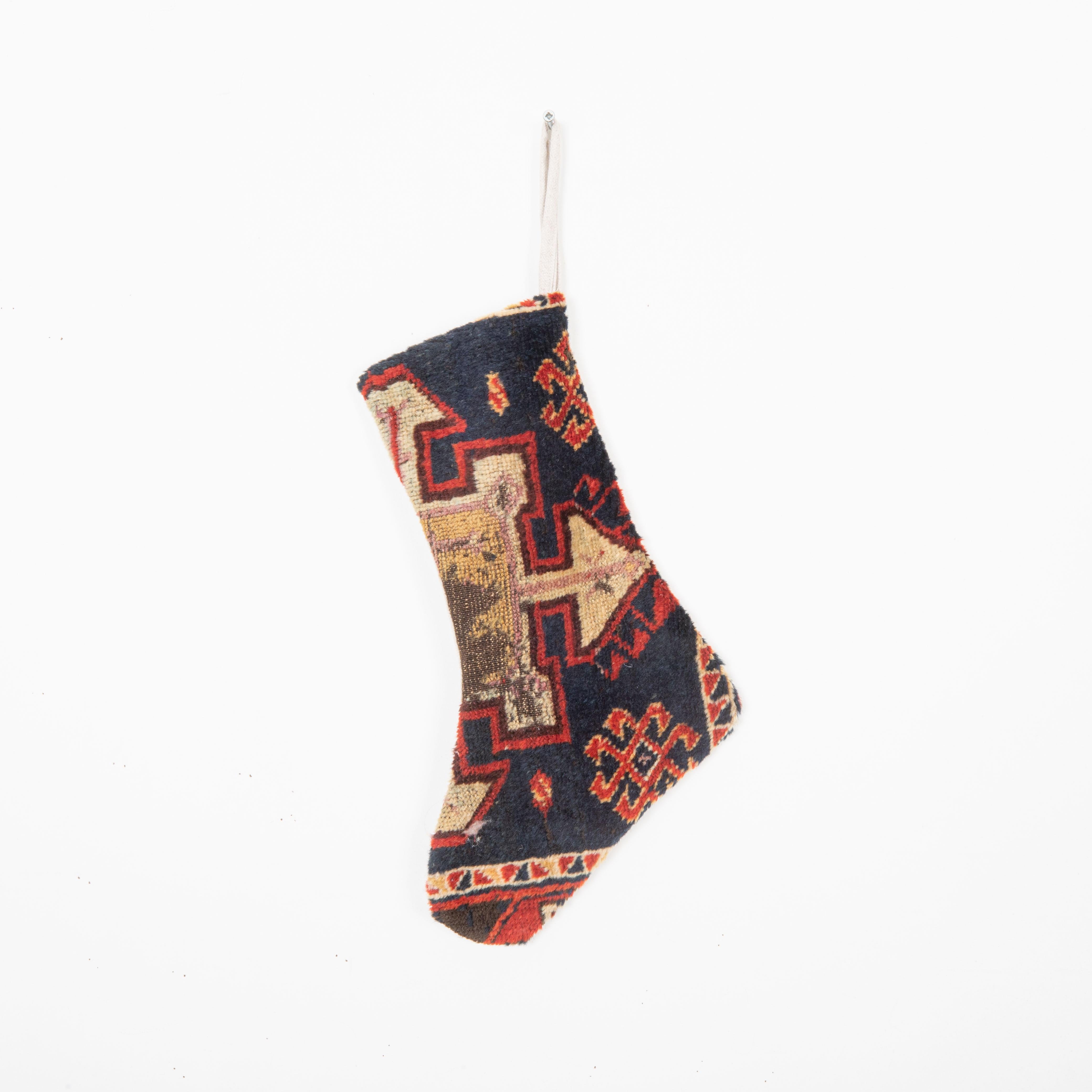 This Christmas Stocking was made from a late 19th or Early 20th C. Anatolian rug fragments.
Linen in the back.

Please note, this stocking was made from Anatolian rug fragments.
