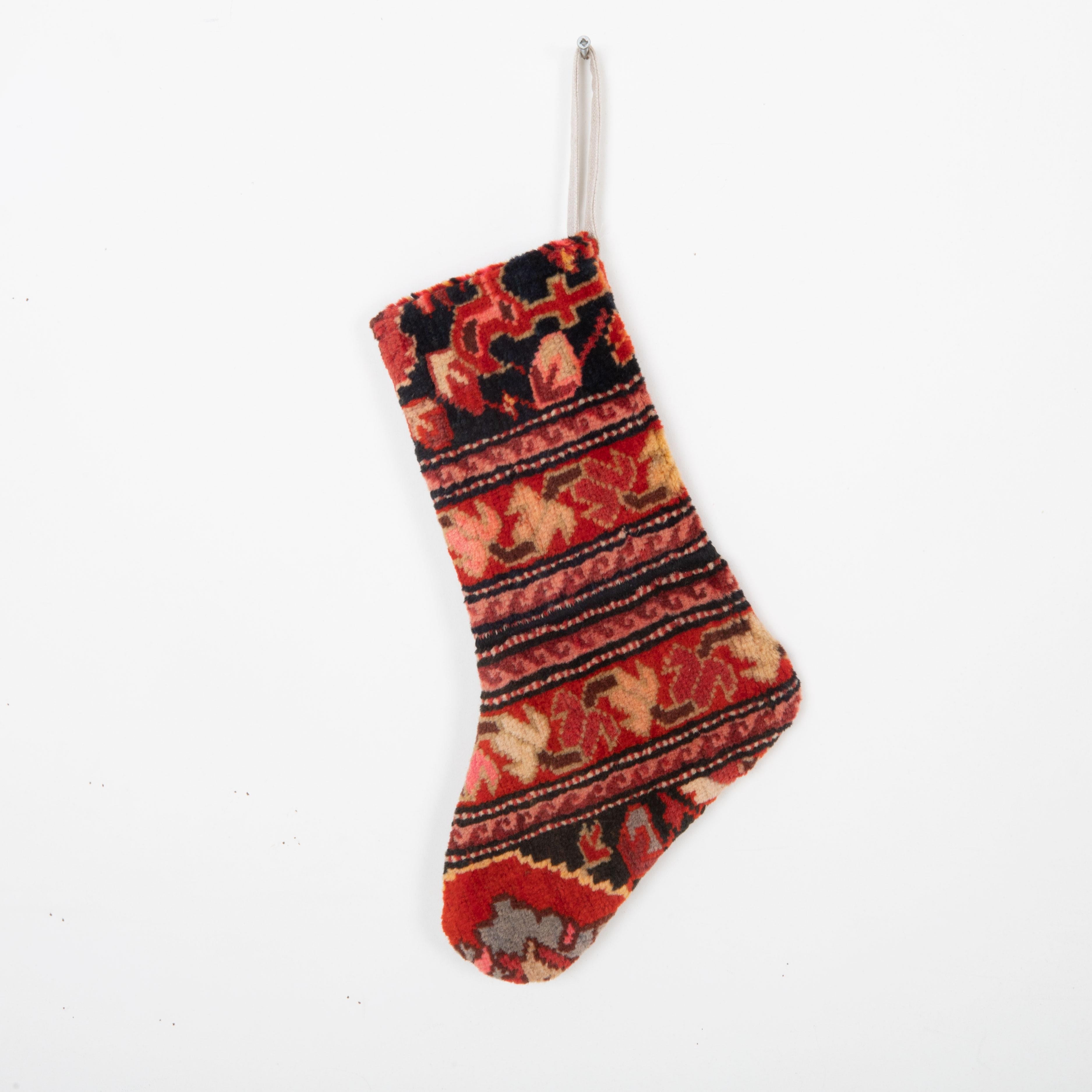This Christmas Stocking was made from a late 19th or Early 20th C. Caucasıan rug fragments.
Linen in the back.

Please note, this stocking was made from caucasian rug fragments.
