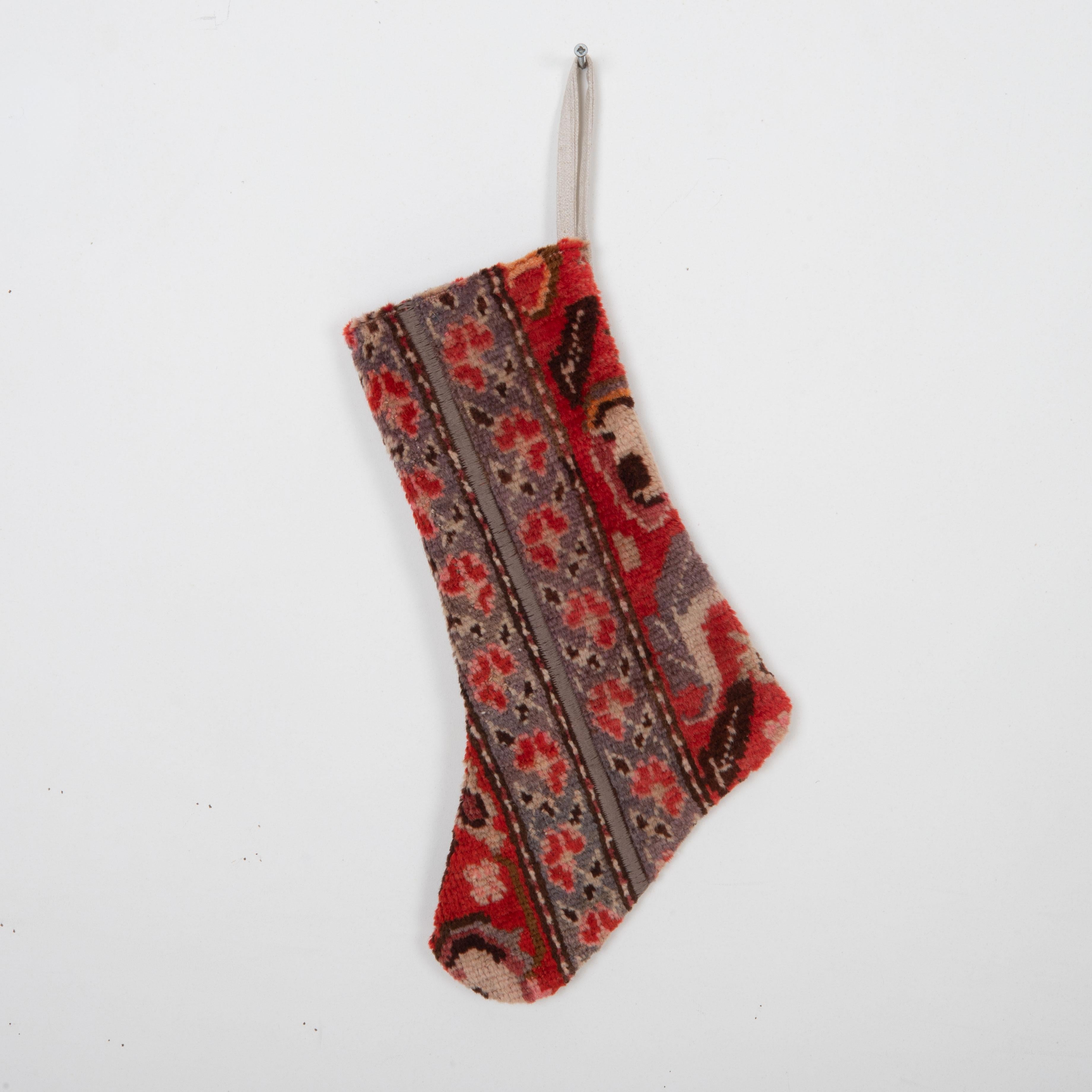 This Christmas Stocking was made from a late 19th or Early 20th C. Caucasian rug fragments.
Linen in the back.

Please note, this stocking was made from caucasian rug fragments.
