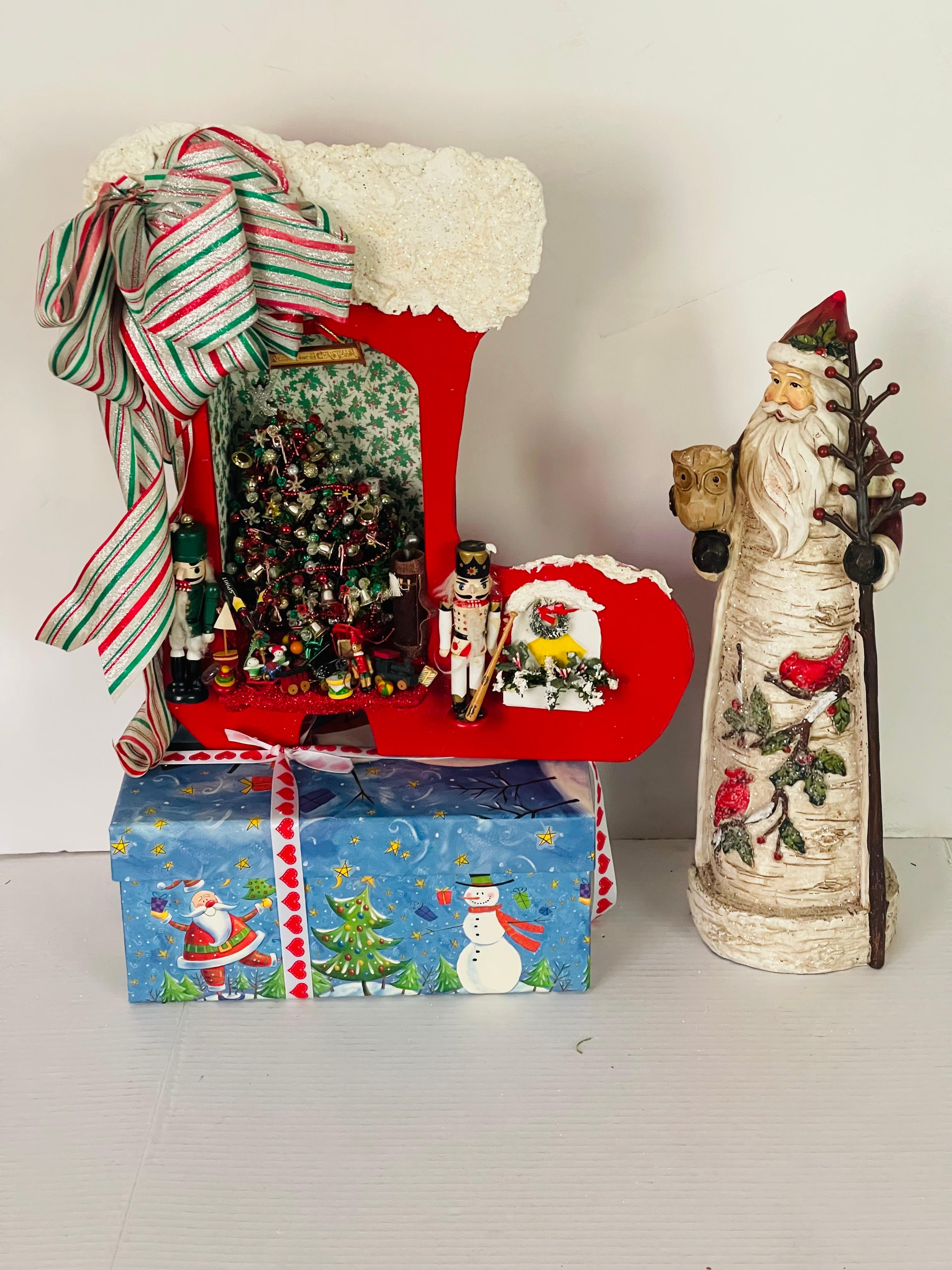Esposizione di giocattoli natalizi artigianali con albero di Natale in miniatura con luci a batteria e statuetta di Babbo Natale in legno intagliata a mano. Giocattoli unici da collezione Van Holiday.