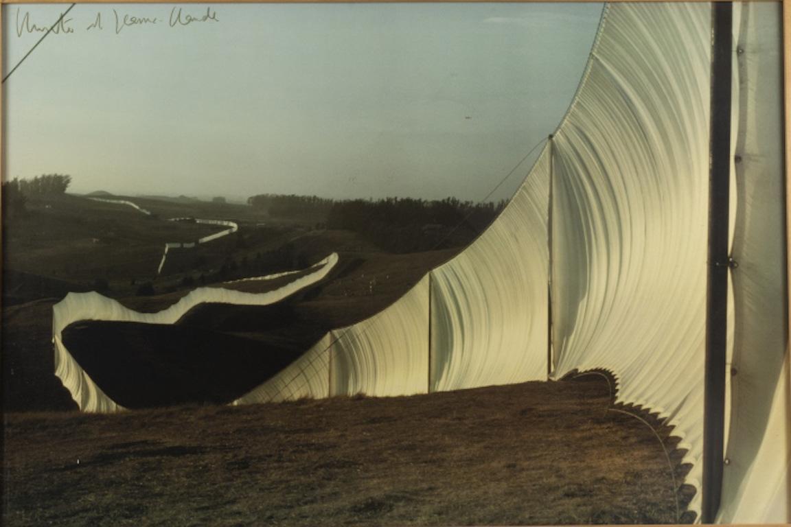Offset lithograph on wove paper, signed by Christo and Jeanne Claude, printed from a photograph by Jeanne Claude, from an edition of 300, published by Poligrafa, Barcelona, 1976
Full sheet 25in. H x 37in. L
In natural wood gallery frame: 26in. H x