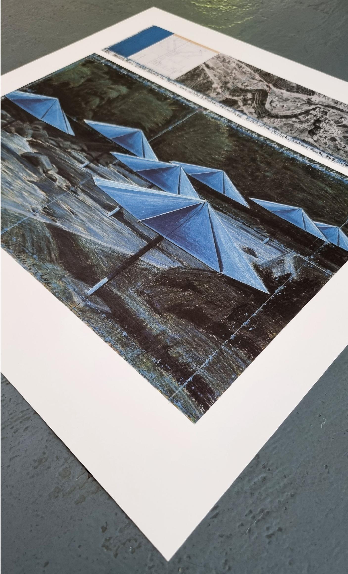 The Umbrellas (Blue) (ENCADRÉ - NOIR OU BLANC - AU CHOIX - LIVRAISON GRATUITE AUX ÉTATS-UNIS) - Print de Christo and Jeanne-Claude