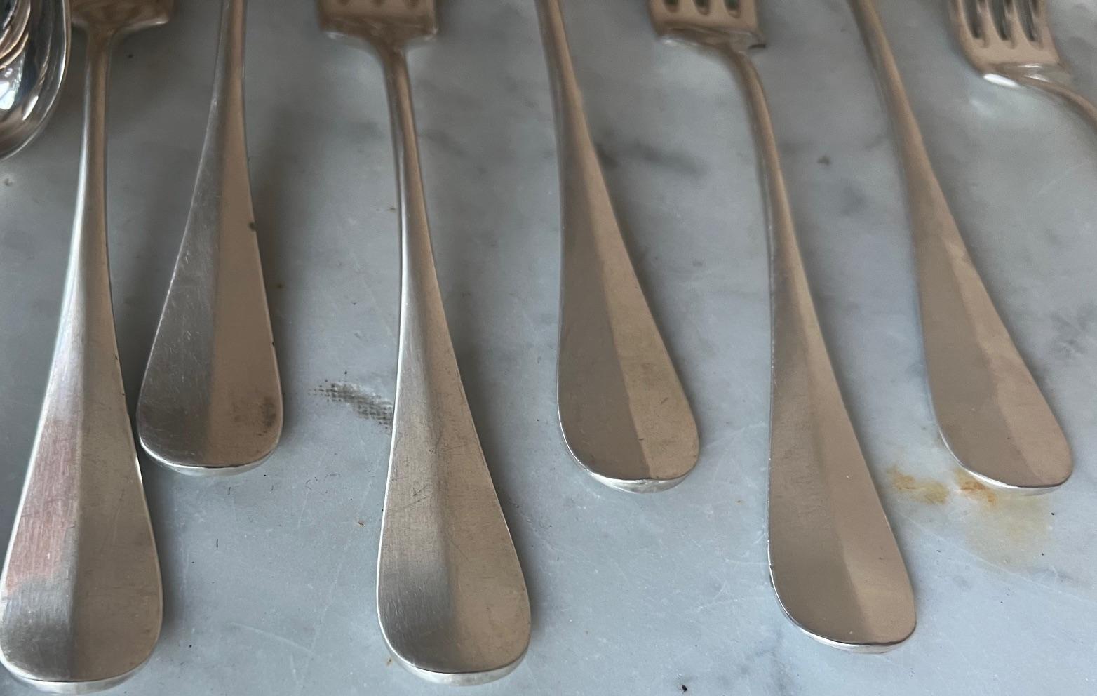Set of 24 flatware pieces which includes 12 forks and 12 spoons was made by Charles Christofle in France in the 1890's. The pattern which is one of  Christofle's first, is called Baguette and was made from 1877 to 1899. Each piece is hallmarked with