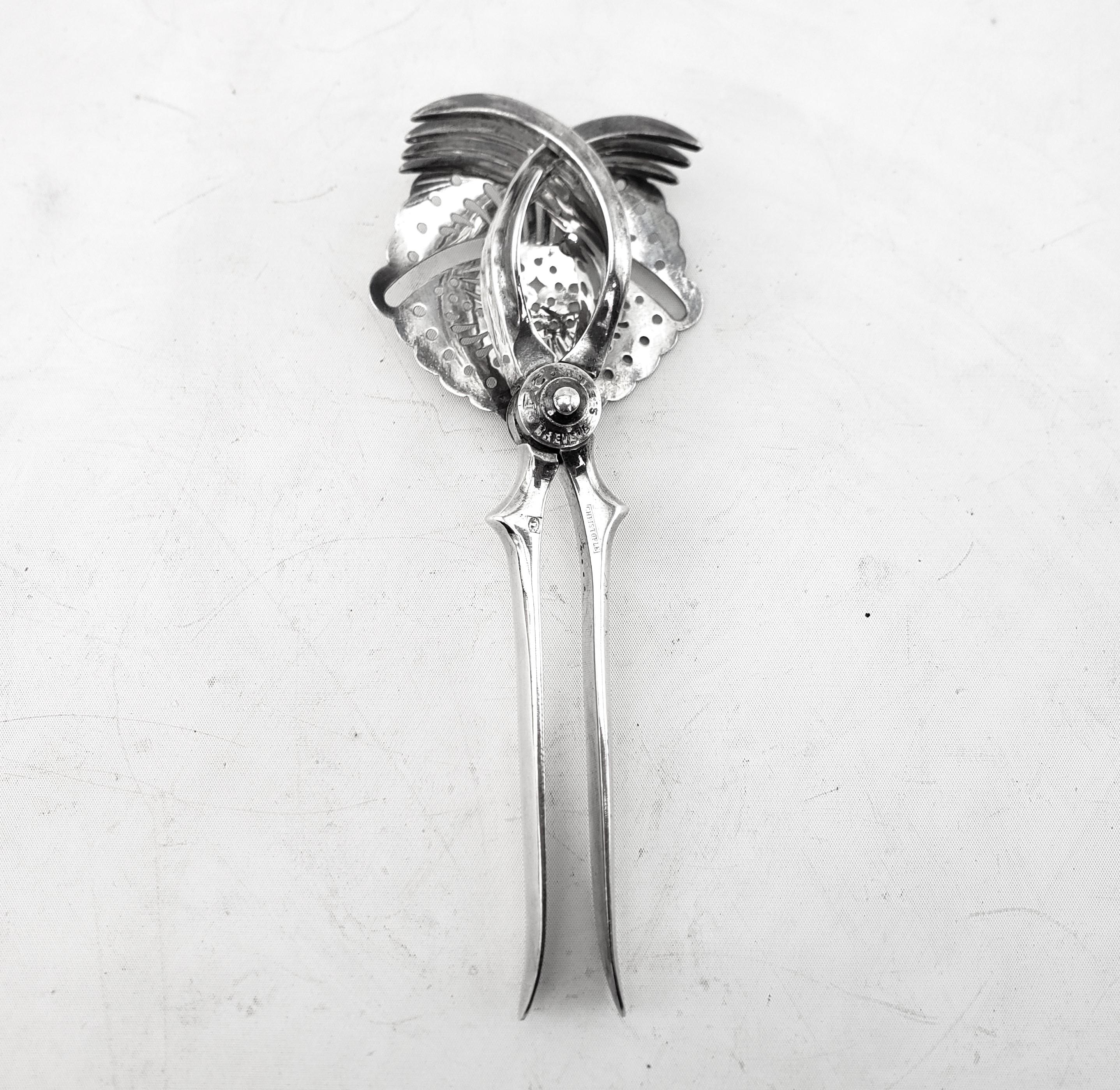 This antique citrus press or juicer was made by the renowned Christofle Silver Company of France and dates to approximately 1920 and done in an Edwardian style. This well made and heavy press is composed of silver plate and works with a scissor