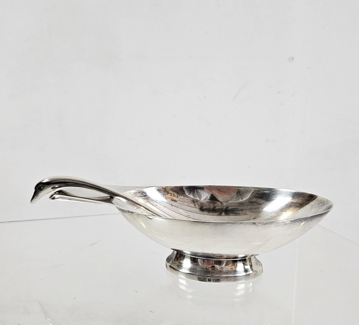 Diese originale Art Deco-Sauciere aus Silberblech in Form eines Schwans besteht aus einer länglich-ovalen Schale mit einem flachen Henkel, der die Schwanzfedern bildet, einem tiefen Becken und einem abgerundeten, gekniffenen Fuß. Der dazu passende