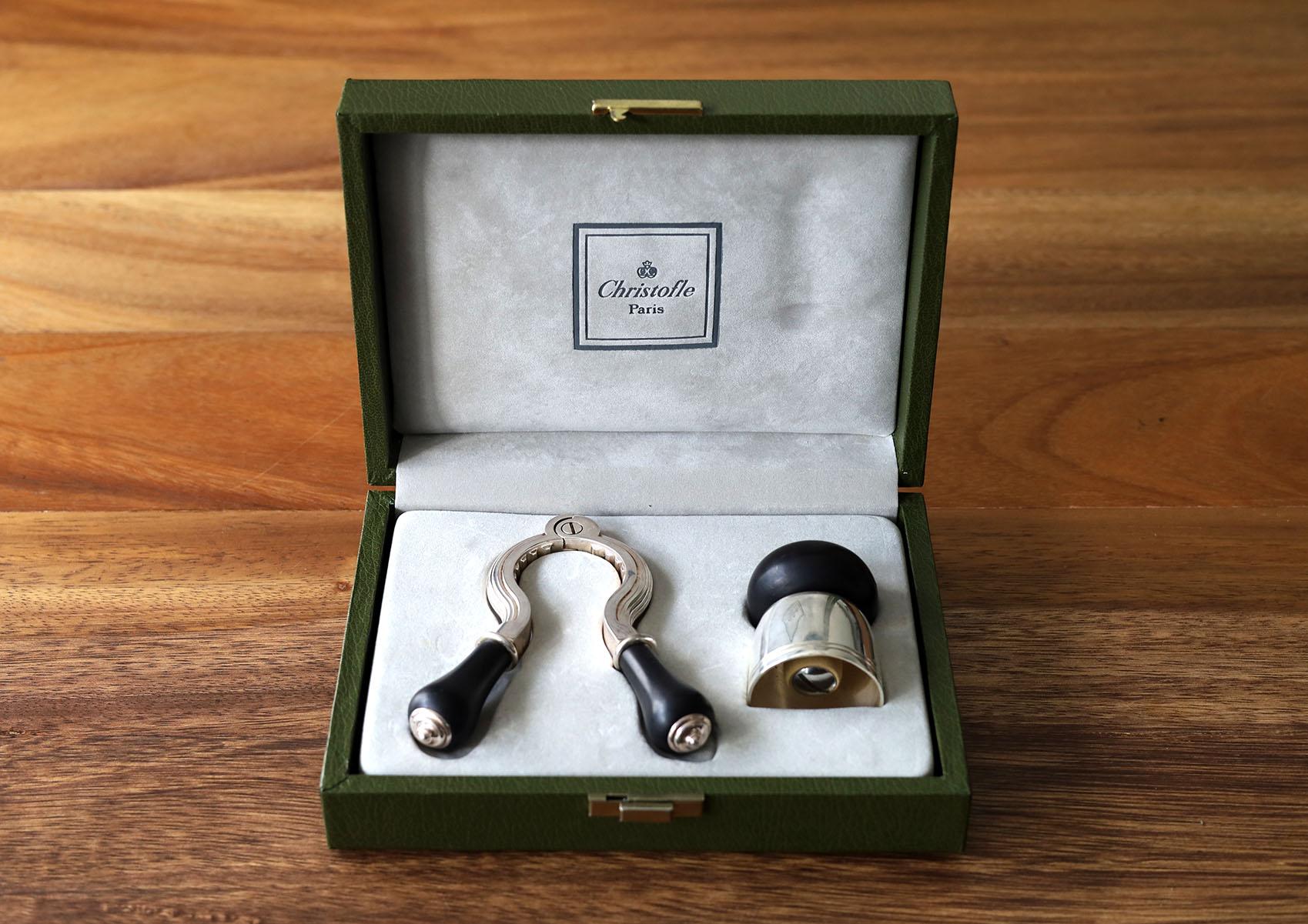 Boxed Christofle champagne set cork puller & bottle stopper with solid wood handles. The corkscrew puller is marked with the Christofle France impressed hallmark.
Really nice.