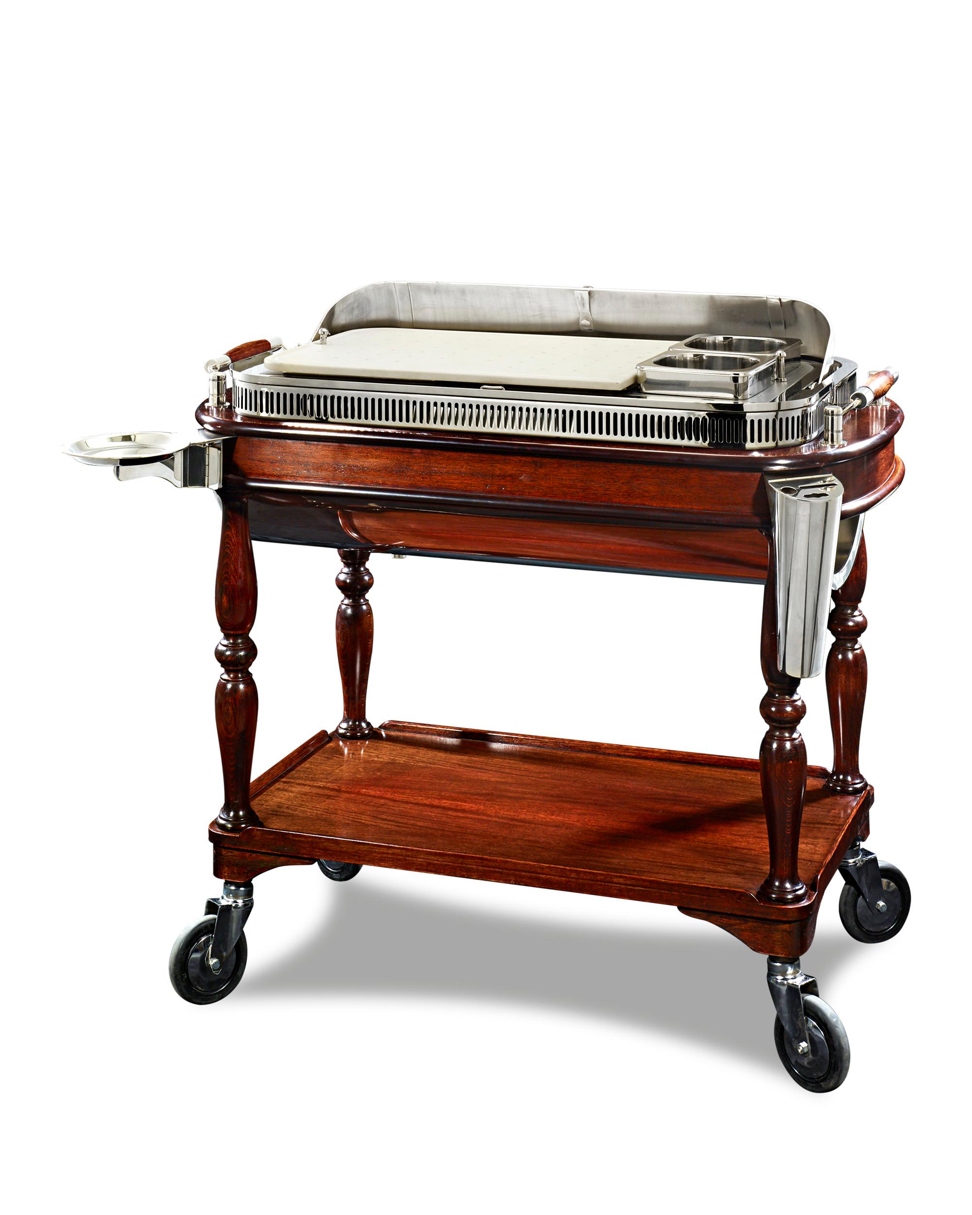 This extraordinary silver plate meat carving trolley was crafted by the prestigious firm Christofle & Cie. As a whole, the trolley makes an impressive display thanks to its large, elegant form resting upon a wheeled mahogany base. Raise the lid of