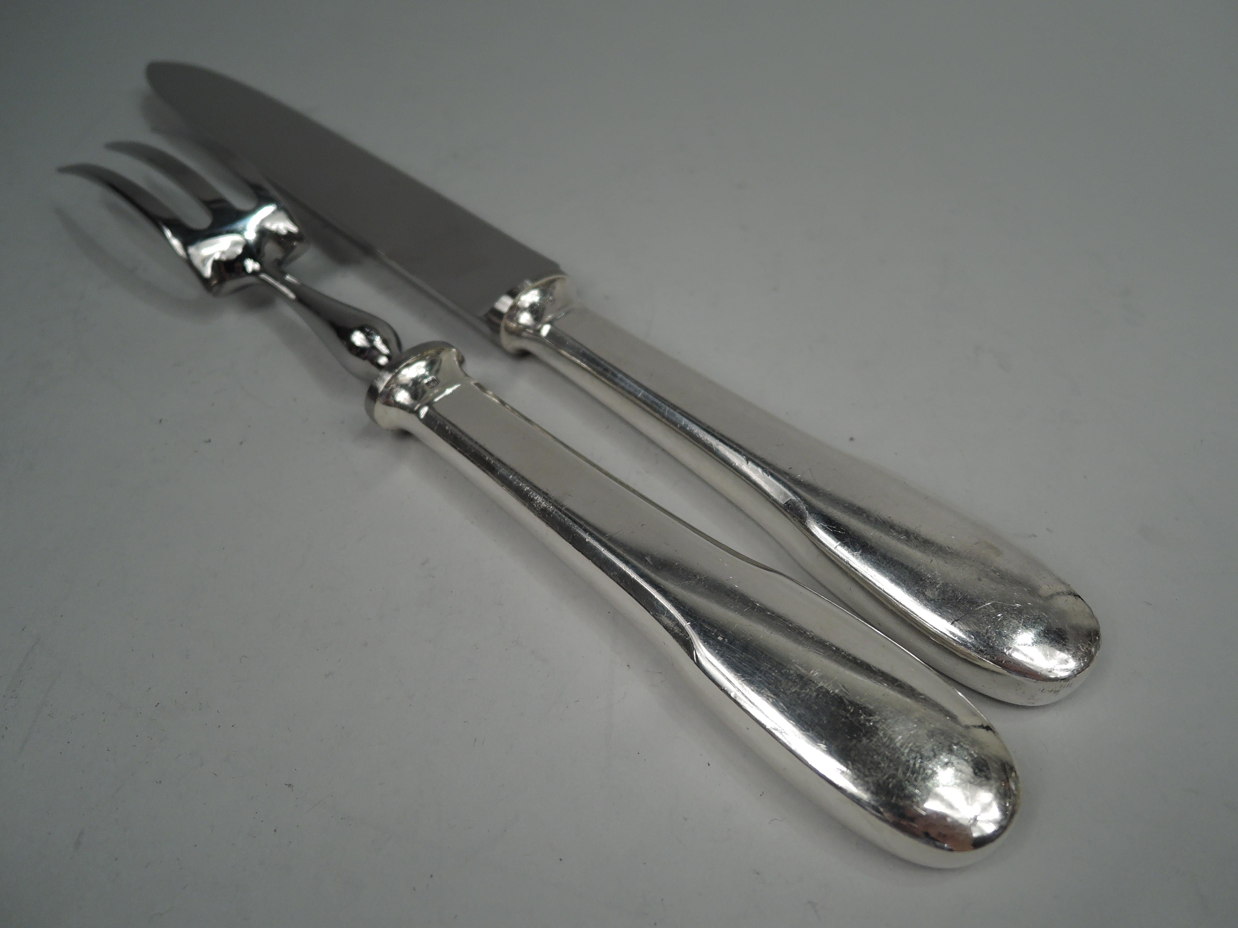 Modern carving pair with knife and fork. Made by Christofle in France, ca 1970. Tapering easy-grip silver-plated handles. Knife blade and 3-tine shank are stainless steel. Handy for the holidays and all the days in between. Marked.  

Dimensions: