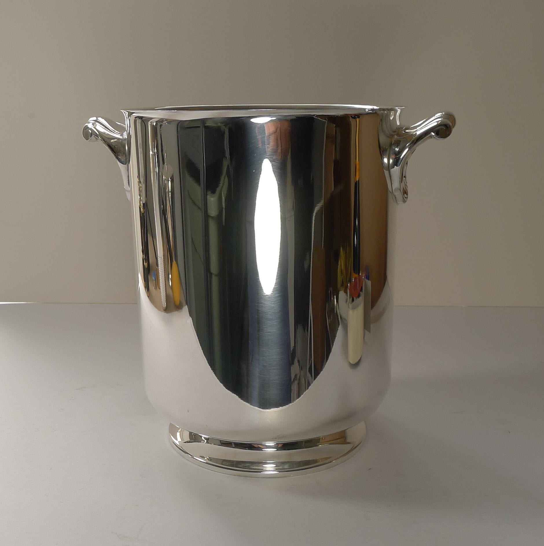 A stunning vintage champagne bucket in silver plate, a hefty quality piece by the famous French Orfevrerie Christofle of Paris.

This design is called Ormesson with it's simple lines and footed base and two fabulous shell handles a lovely post Art