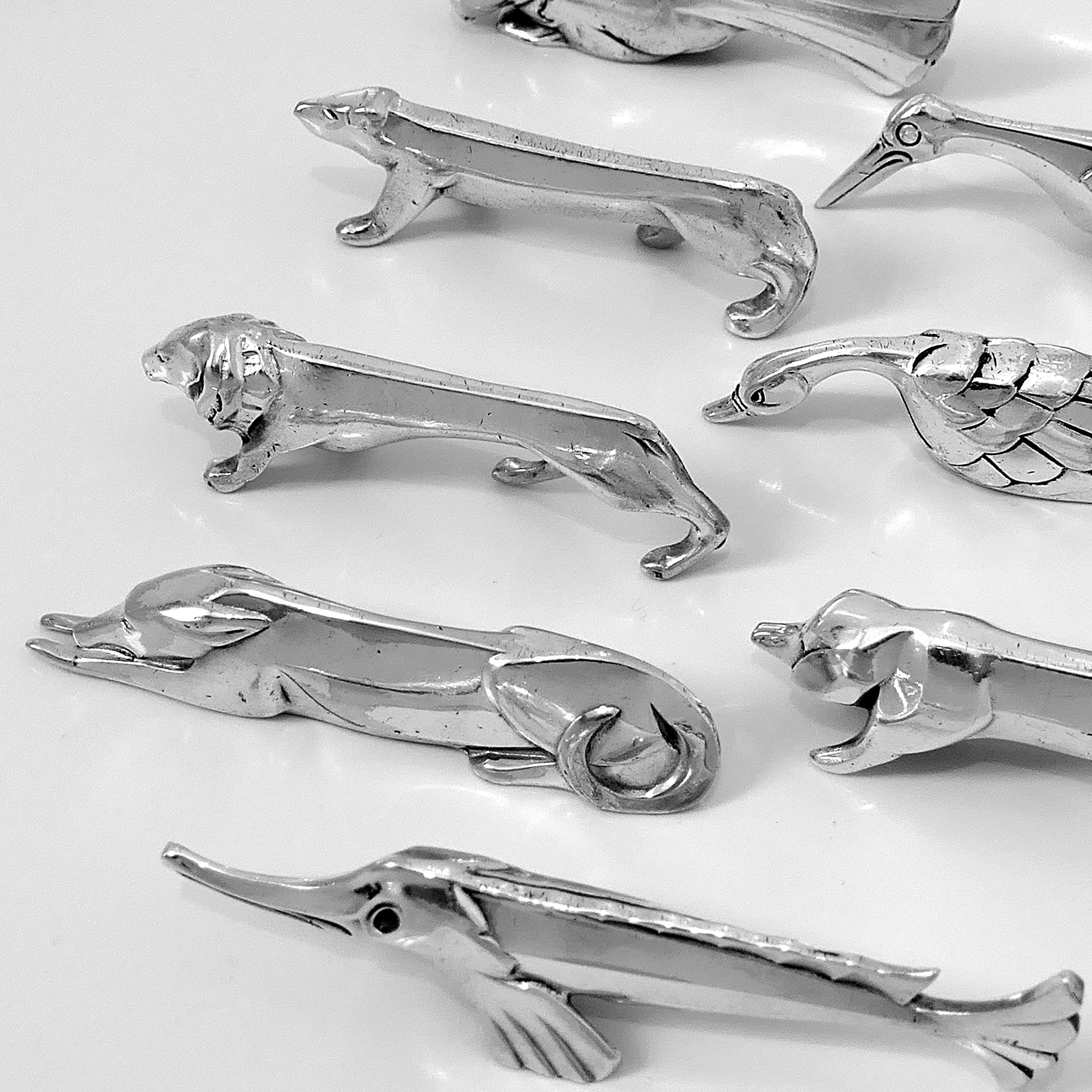 Rare set of eight silver plated knife-rests in the shape of different animals: dove, bear, lion, pig, greyhound, sturgeon, swan and pelican. The knife rests feature the geometric stylization characteristic of the Art Deco style prevalent at that