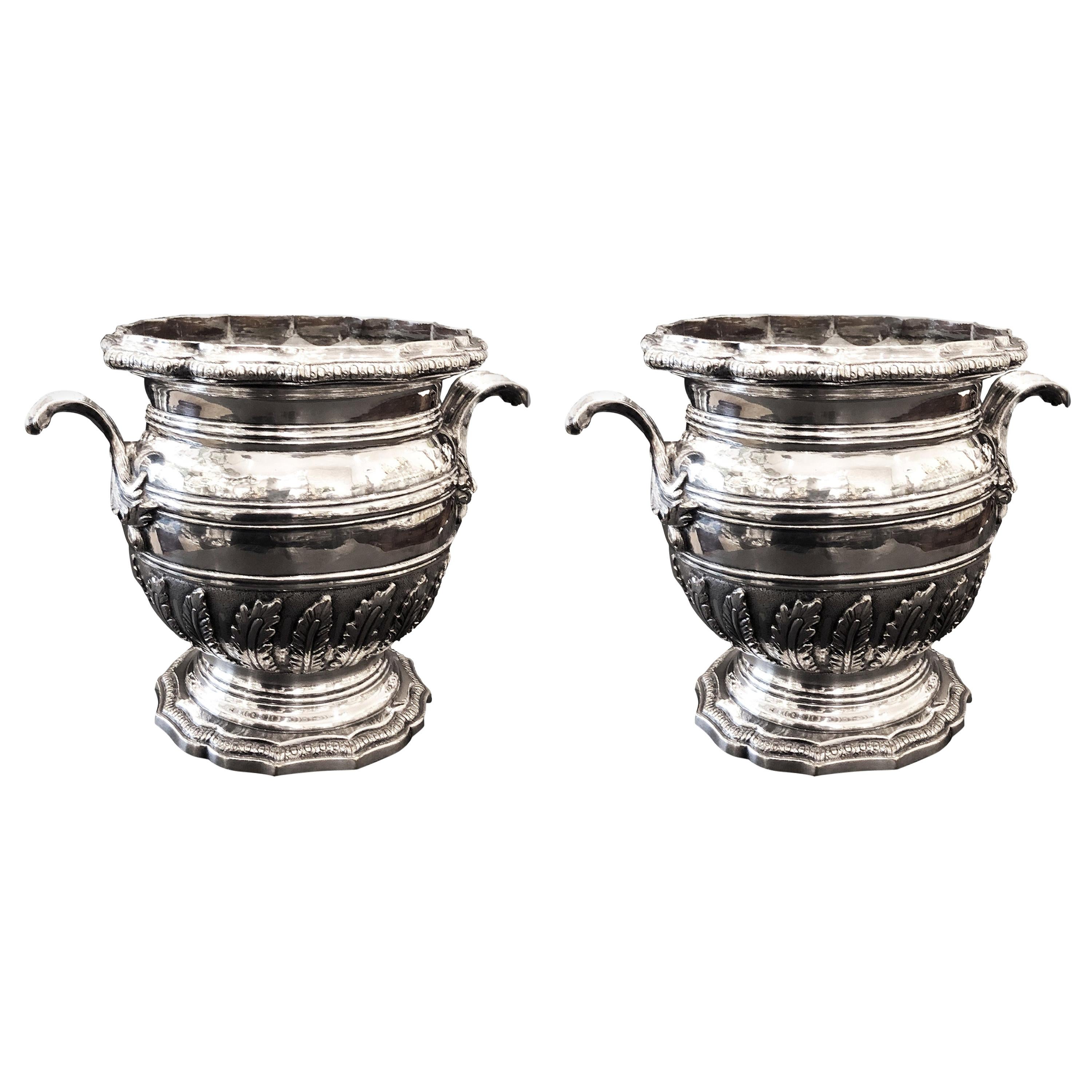 These rare large buckets are, mid-19th century, silver plated with a very nice patina, very talented work.
Their baluster form on stand, rocaille style, decorated with vegetal leaves reminds of Juste Aurèle Meissonnier style, 

Christofle is one