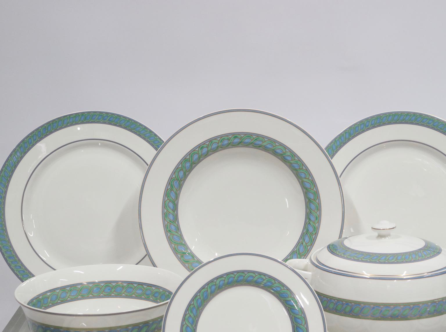 Never used partial service of Christofle porcelain servewear in the blue and green Torsada pattern. The set consists of 43 pieces, serves six people and is in like new condition with almost all pieces having their original box and packaging. This