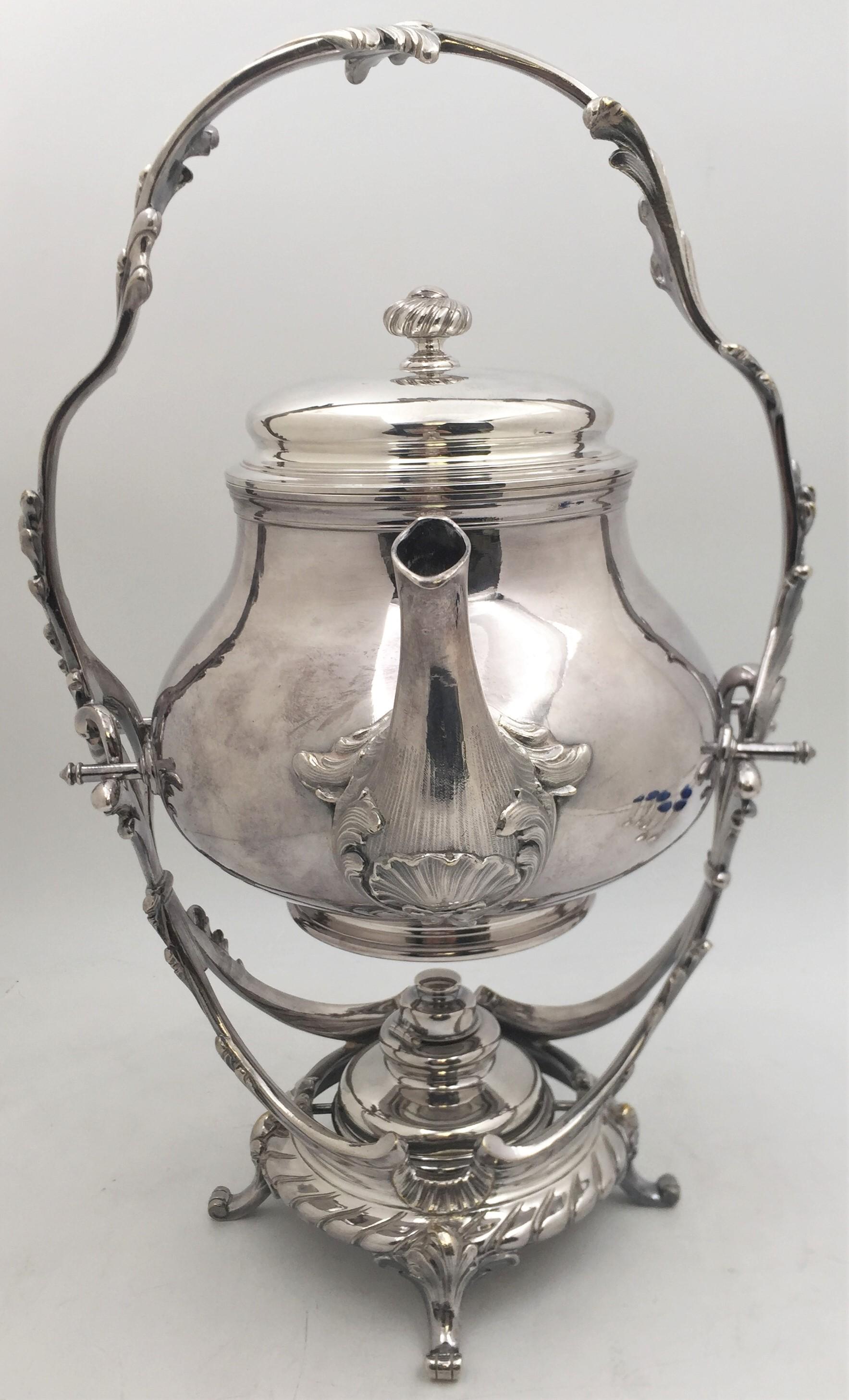 Hervidor plateado Christofle sobre soporte de estilo rococó ornamentado con motivos naturales arremolinados. El soporte, que tiene 4 patas, mide unas impresionantes 16 1/2'' de altura por 7 1/4'' de profundidad. El hervidor mide 8 1/2'' de altura