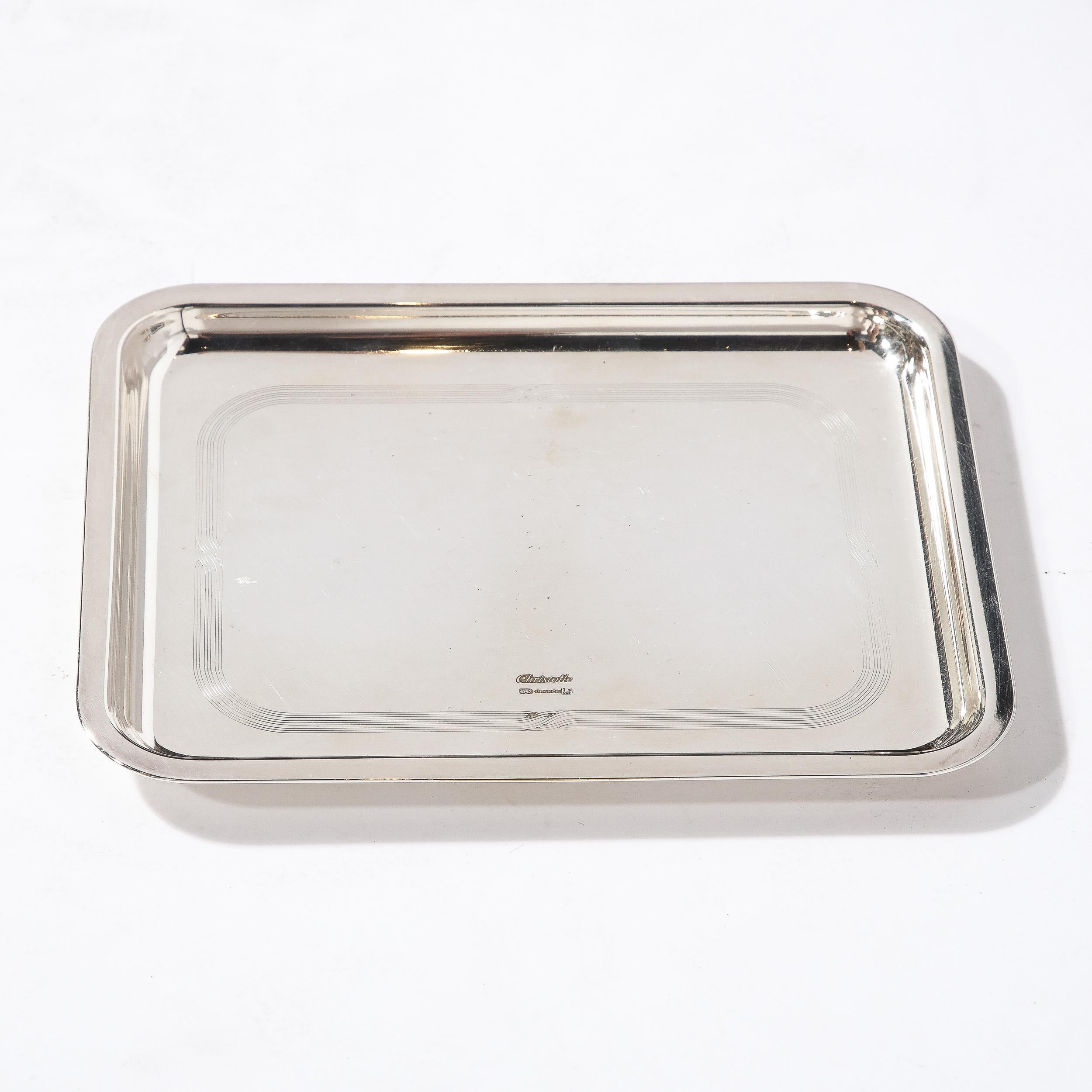 A beautiful silver plated tray by the French house of Christofle. This center of the plate is beautifully engraved with a pattern of interwoven ribbons. Ideal for stylish serving of guests, or purely for decoration. The tray is marked Christofle