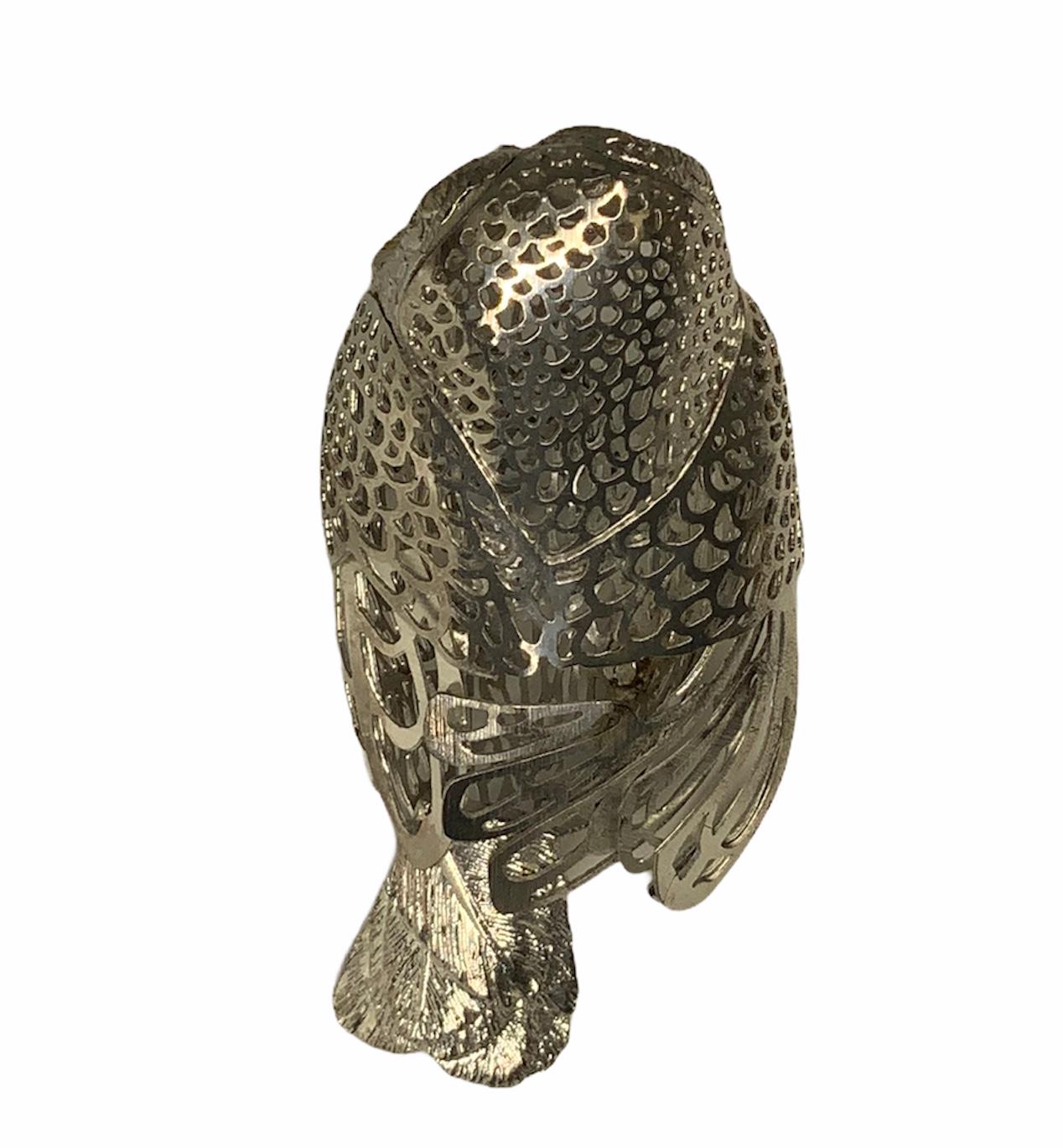 This is a Christofle silver plated lumiere “curious” owl figurine. Its whole body is reticulated and its pair of eyes are highlighted by onyx like enamel beads surrounded by gold tone metal. The Christofle hallmark is in its feather tail. This is