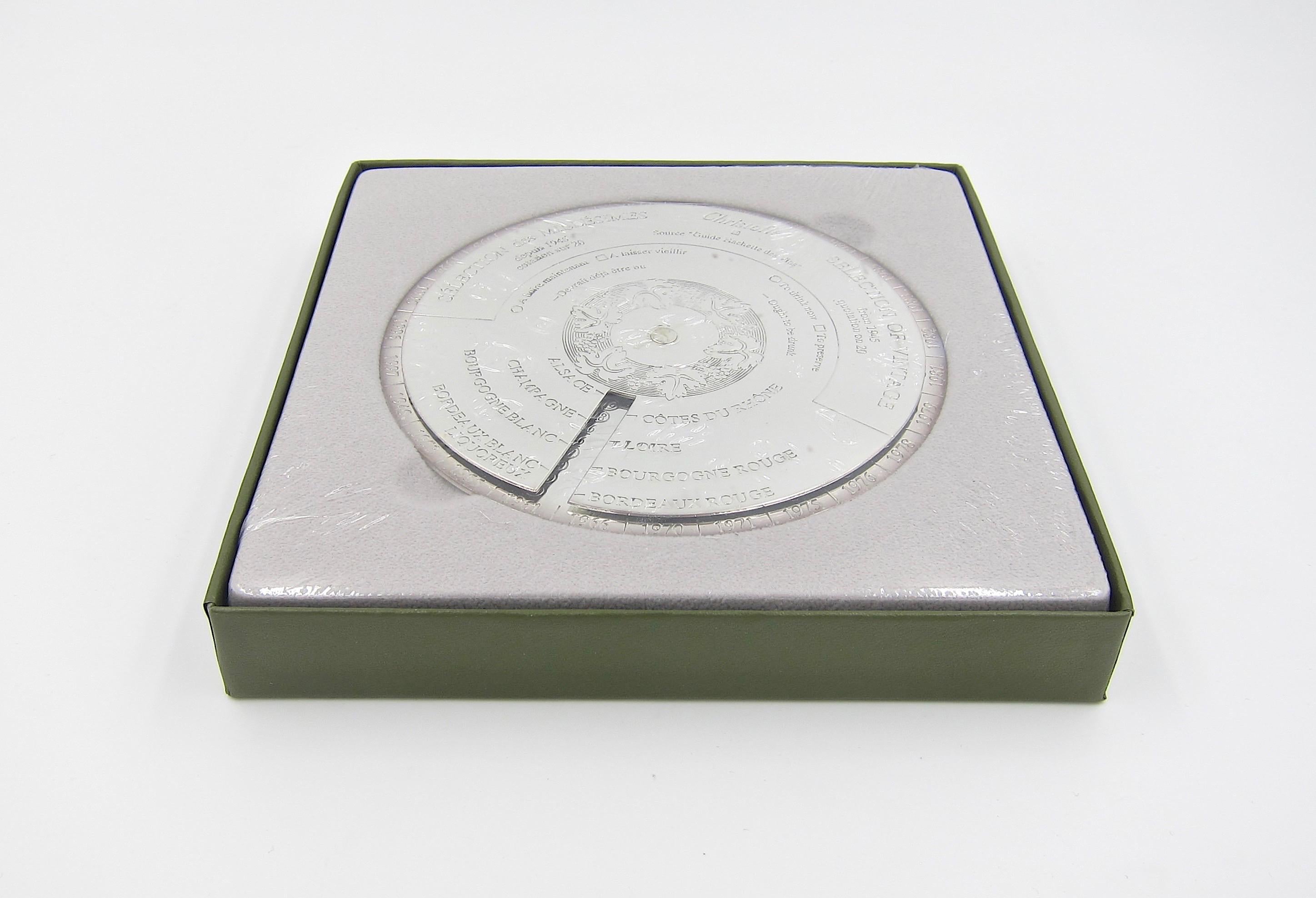 A Christofle of Paris Vinea Dessous de Carafe wine bottle coaster sealed in its original fitted box. Designed as a guide (or cheat sheet) for the true oenophile with an adjustable upper disk that rotates to reflect a 1 through 20 rating from 