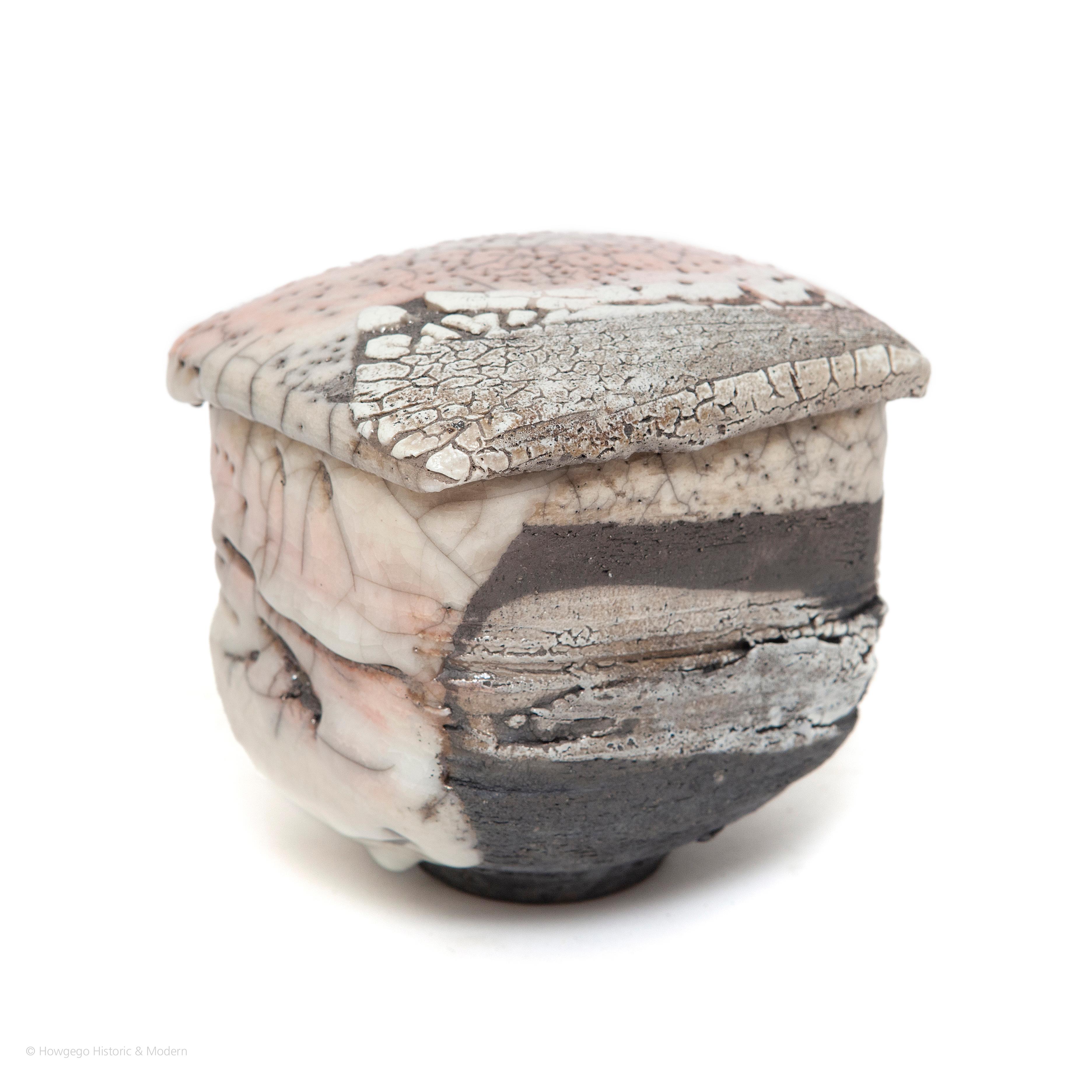 Christoph Zange : Black Raku, ceremonal tea bowl & cover or storage vessel

Raku tea bowls are made by moulding pinching, sculpting by hand; glazing by brush and firing in a muffle kiln fuelled by charcoal removing them from the hot kiln so they