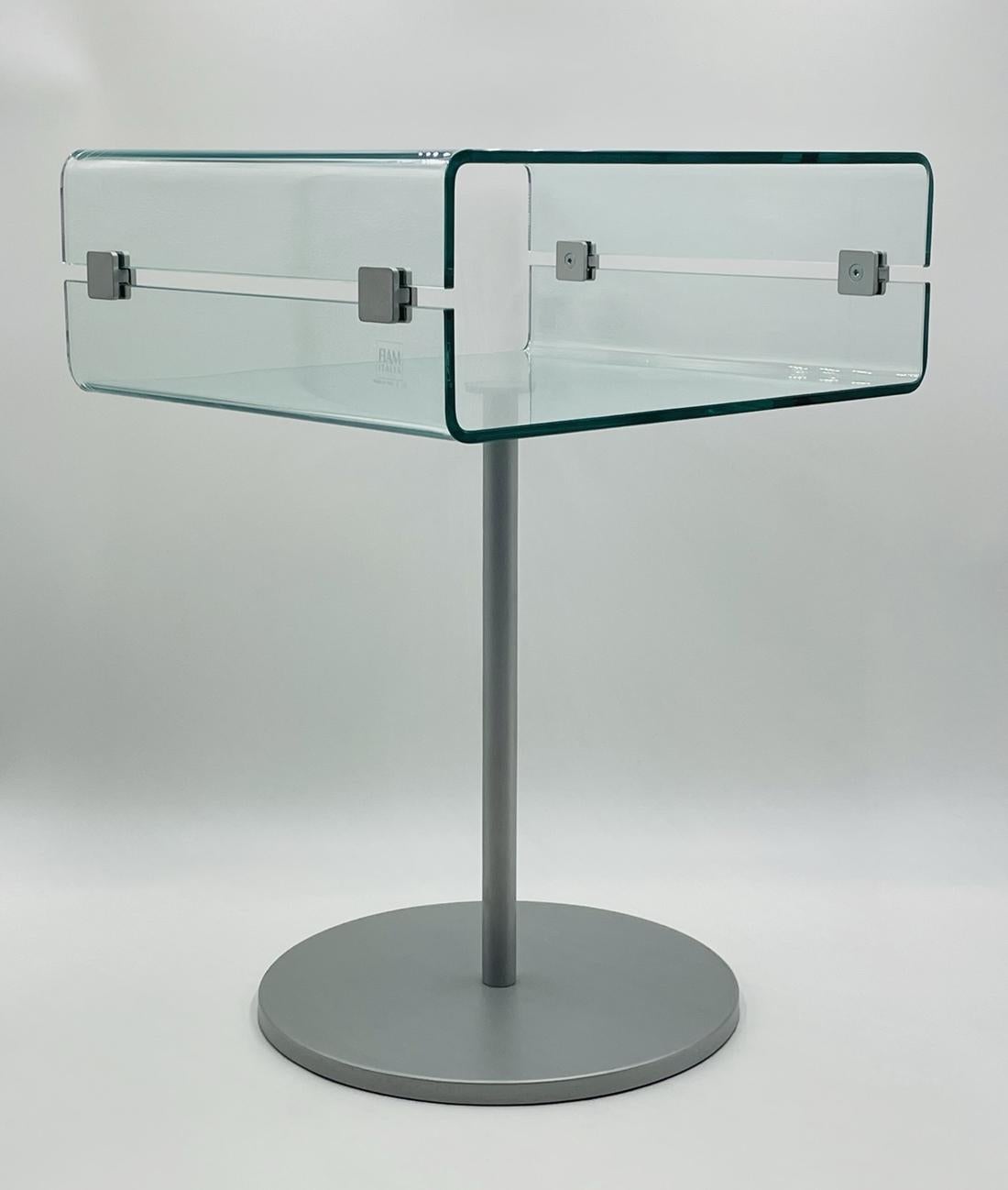 Christophe Pillet C&C Night table. 20th century. Made by Fiam Italia. 

Table having a curved glass top with aluminum hardware raised on a metal base with an aluminum finish.

Marked 