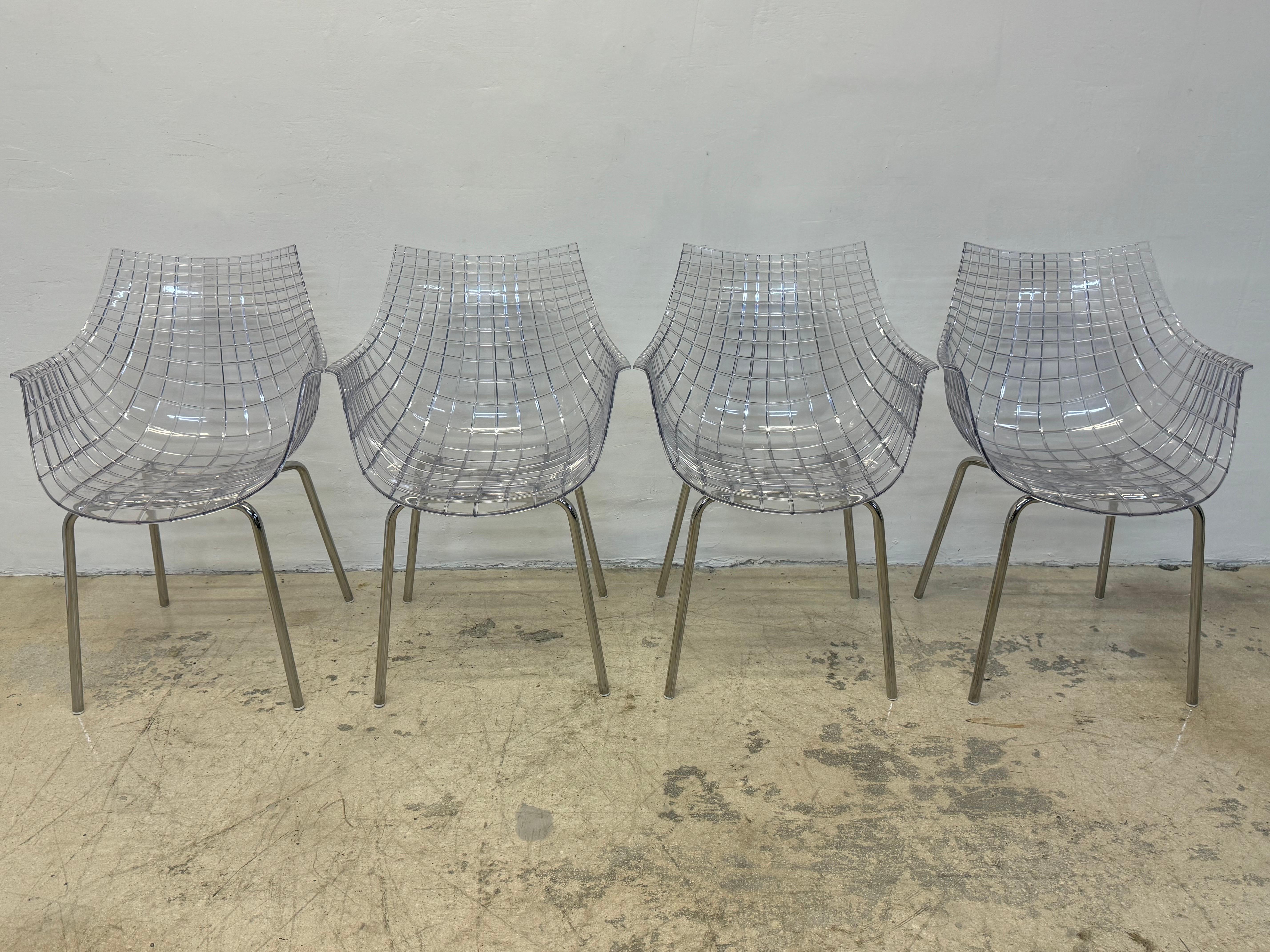 Set of four Meridiana transparent and chrome leg dining chairs designed by Christophe Pillet in 2004 for Dríade.  The moulded plastic seats take their inspiration from cut diamonds to capture and reflect light. 

Christophe Pillet is a renowned