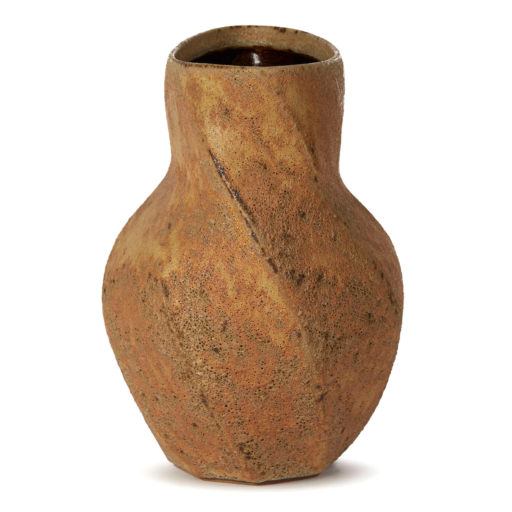 An absolutely stunning one-off studio pottery stoneware vase decorated in textured oxidised glazes by Chris Carter (b.1945). The vase has flat cut bands in a wrythen twist design around the body flattened slightly to form an oval shape with a open