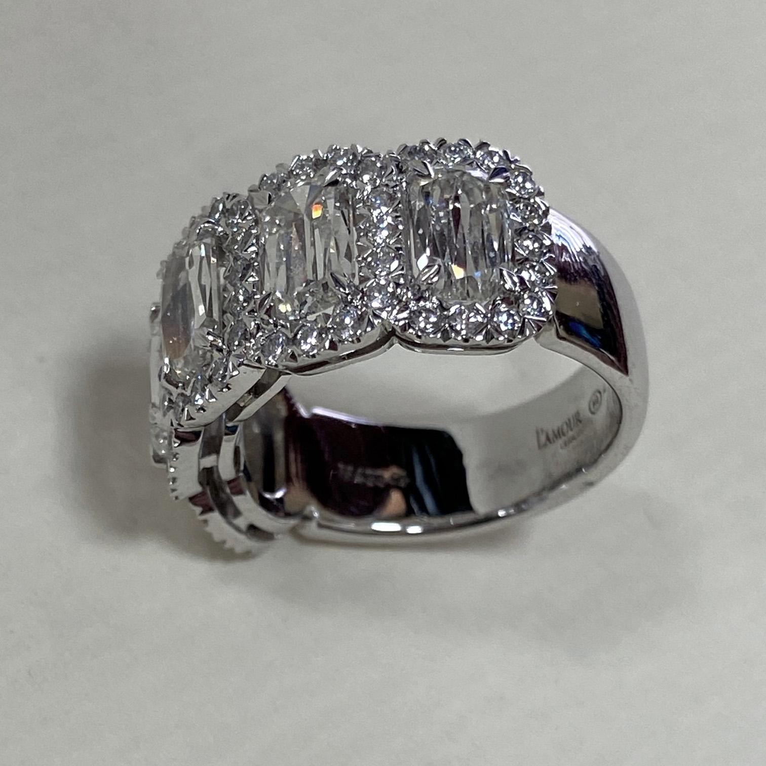 From Christopher Designs in New York, this beautiful 18 karat white gold diamond band showcases five of the designers signature L'amour crisscut, E color, VS clarity, diamonds totaling 2.66 total carats. Adorning the stations are halos of G color,