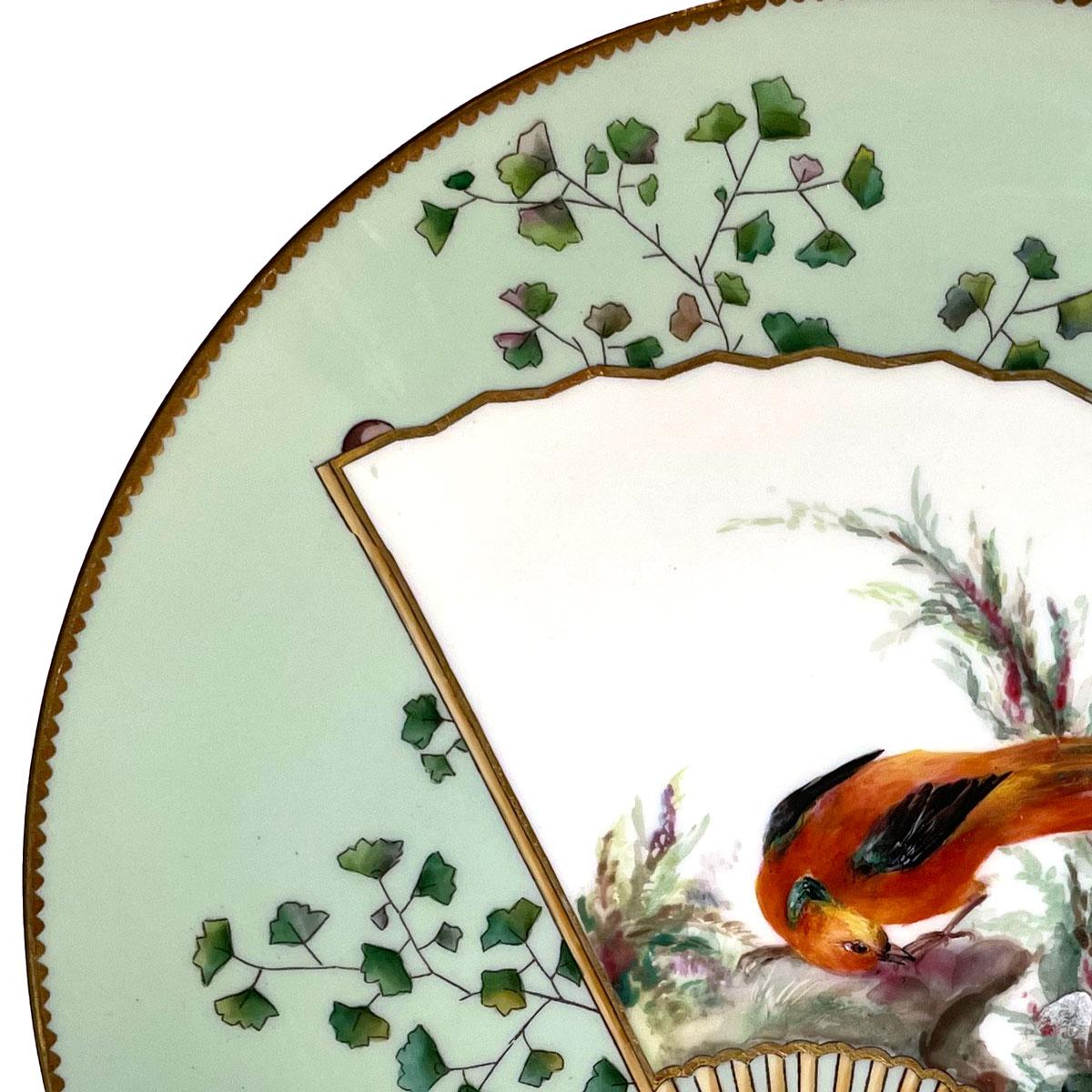 Grüner, ästhetischer Minton-Porzellanteller im Stil des Japonismus, hergestellt von Christopher Dresser. Runder Teller, verziert mit einem orientalischen Fächer, der einen schönen und bunten Vogel darstellt. Hübsche Dekoration mit Pflanzen und