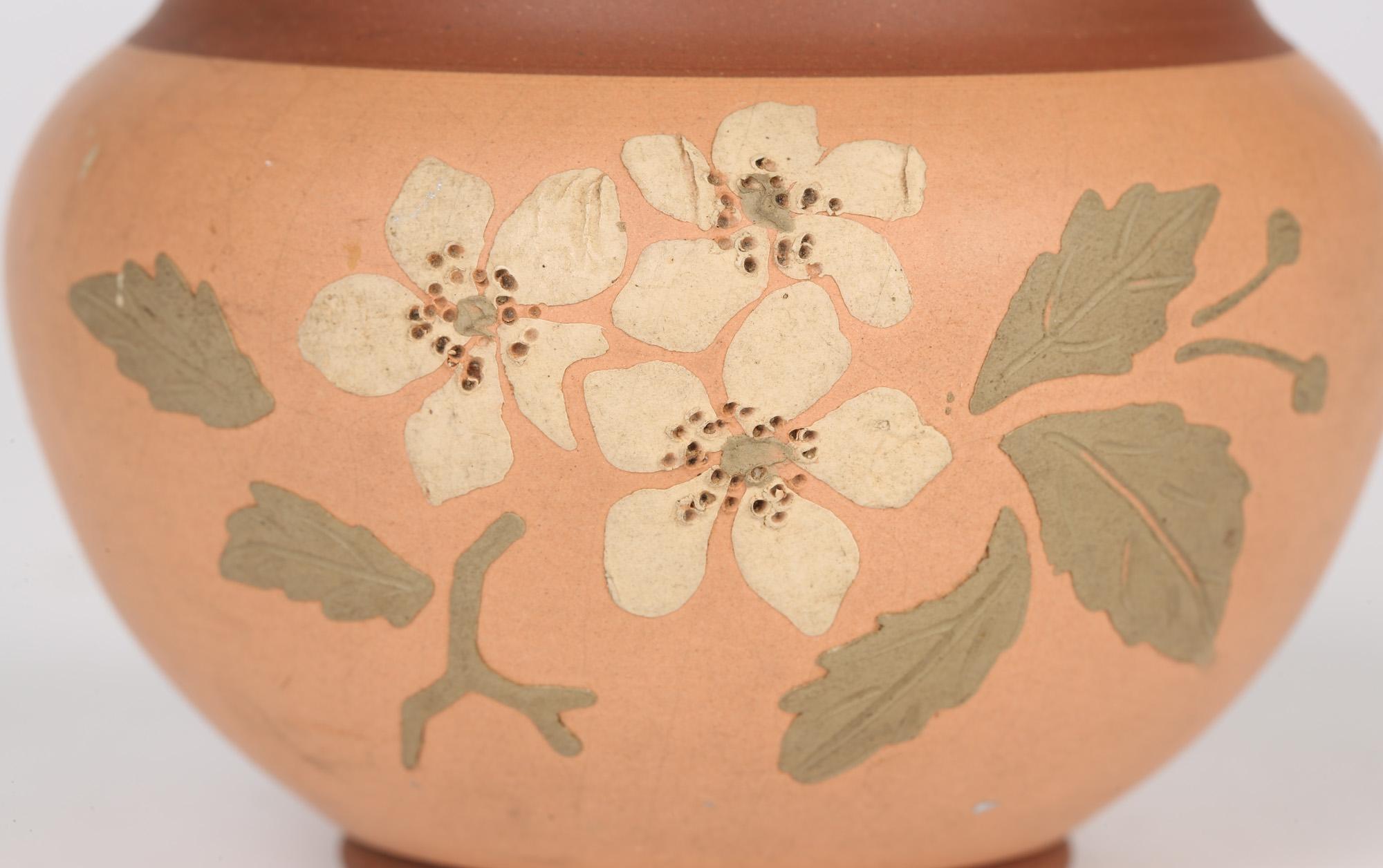 A very stylish aesthetic movement terracotta bowl with slip applied floral designs in the manner of Watcombe and design attributed to Christopher Dresser dating from around 1880. This very finely made bowl stands raised on a narrow rounded foot with