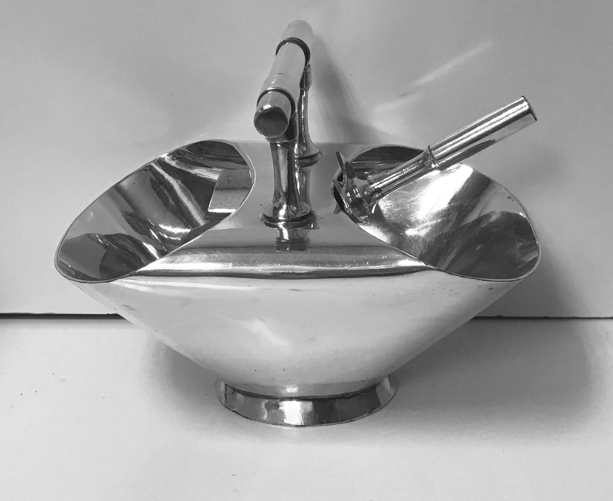 Christopher Dresser designed silver plate double ended Sugar Scuttle, with spoon. England, circa 1890 Walker & Hall. The Sugar scuttle, plain oval slightly spreading footed base, with central plain handle. Stamped on the underside 1995 and 76 Walker