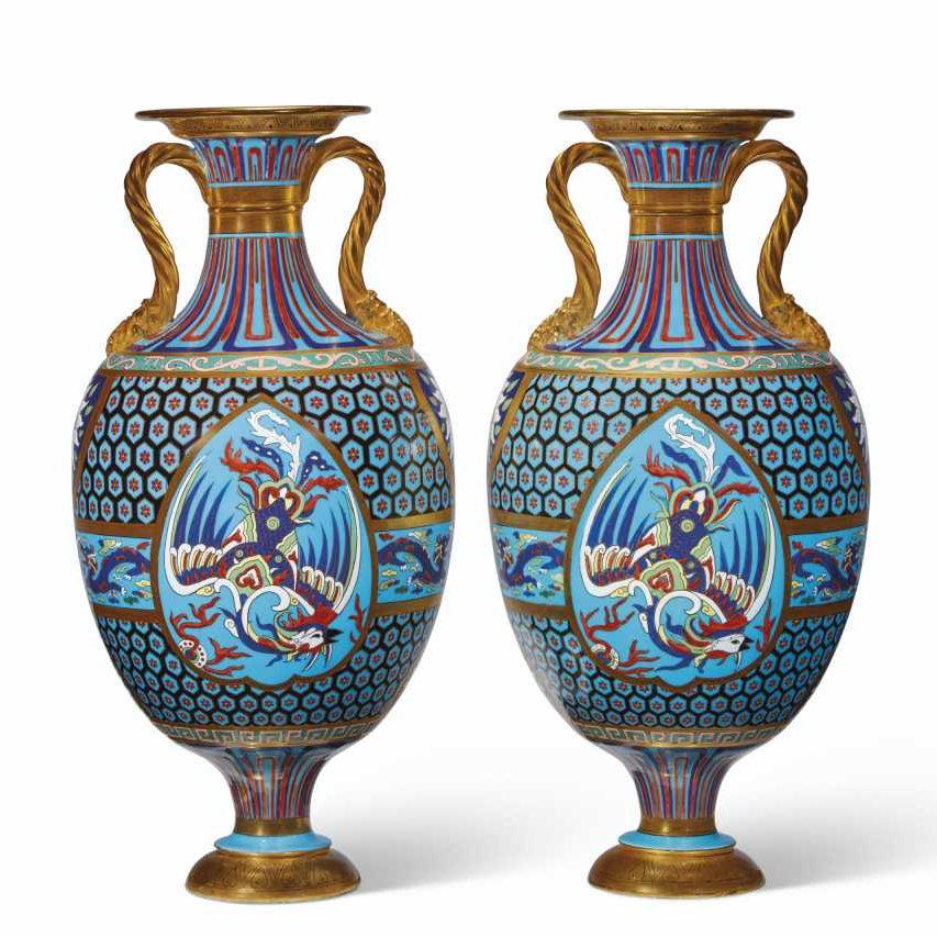 Our exceptional pair of enameled porcelain vases in the Chinese cloisonné style were designed by Christopher Dresser (1834-1904) for Mintons. 
 They feature one side with a dragon and other with a phoenix, reserved on a blue cell-pattern ground, and