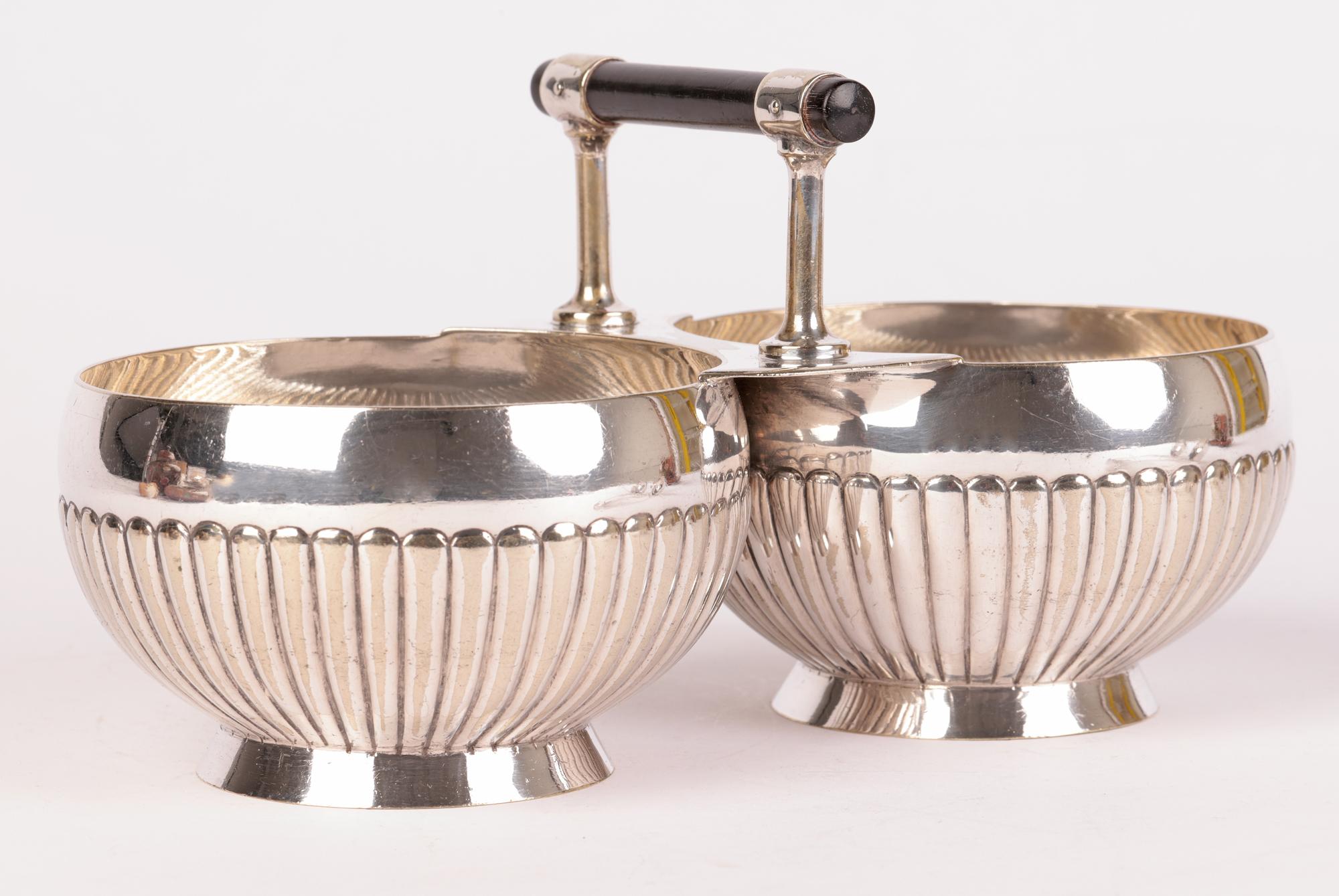 A very stylish Arts & Crafts Hukin & Heath twin silver plated sugar bowl and matching ladles designed by Christopher Dresser and dating from around 1890. The two bowls are of round shape supported on flared bases and joined with a flat edge mounted