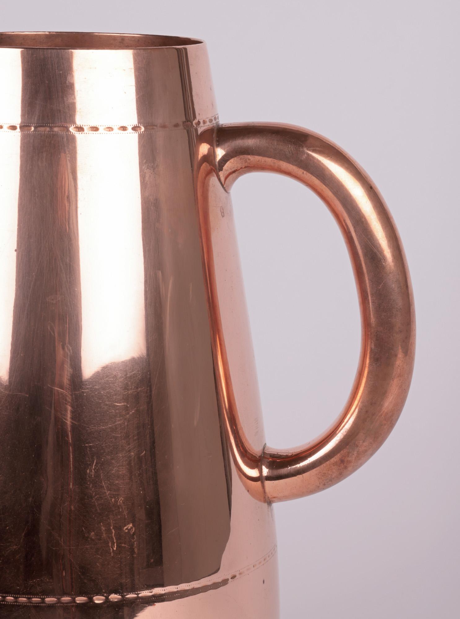 A large and exceptional aesthetic movement copper ale jug designed by renowned designer Christopher Dresser for Richard Hodd & Sons dating from around 1880. The tall stylish ale jug has a teardrop shaped body with a wide rounded base and stands