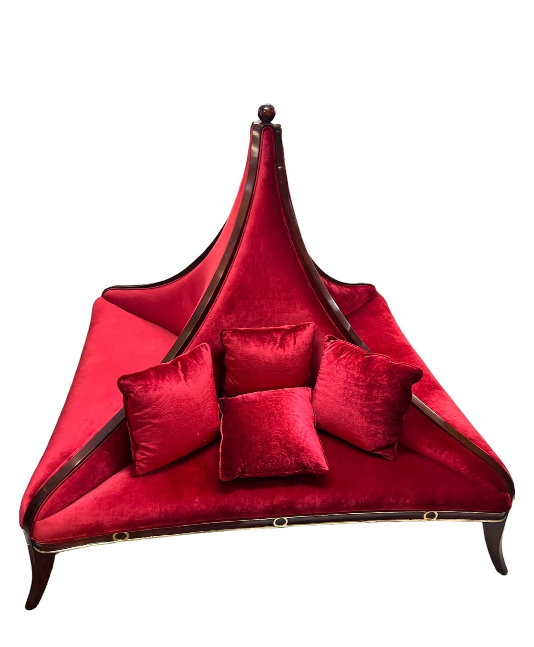 Designed by renowned furniture designer Christopher Guy, this centerpiece sofa combines elegance with comfort. The plush red velvet upholstery adds a touch of glamour, while the sofa's unique, curvaceous silhouette showcases the impeccable